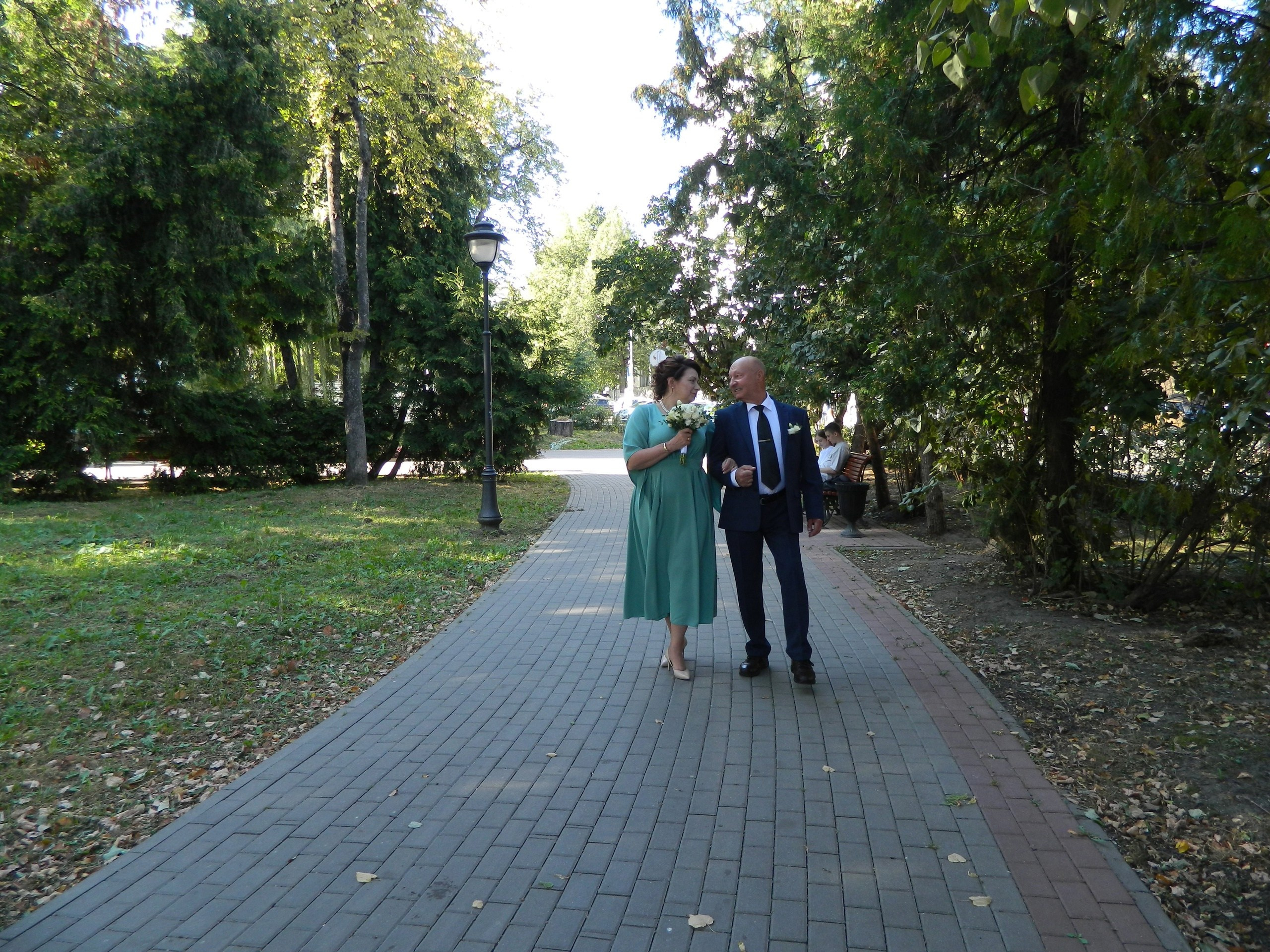 молодожёны идут по аллее