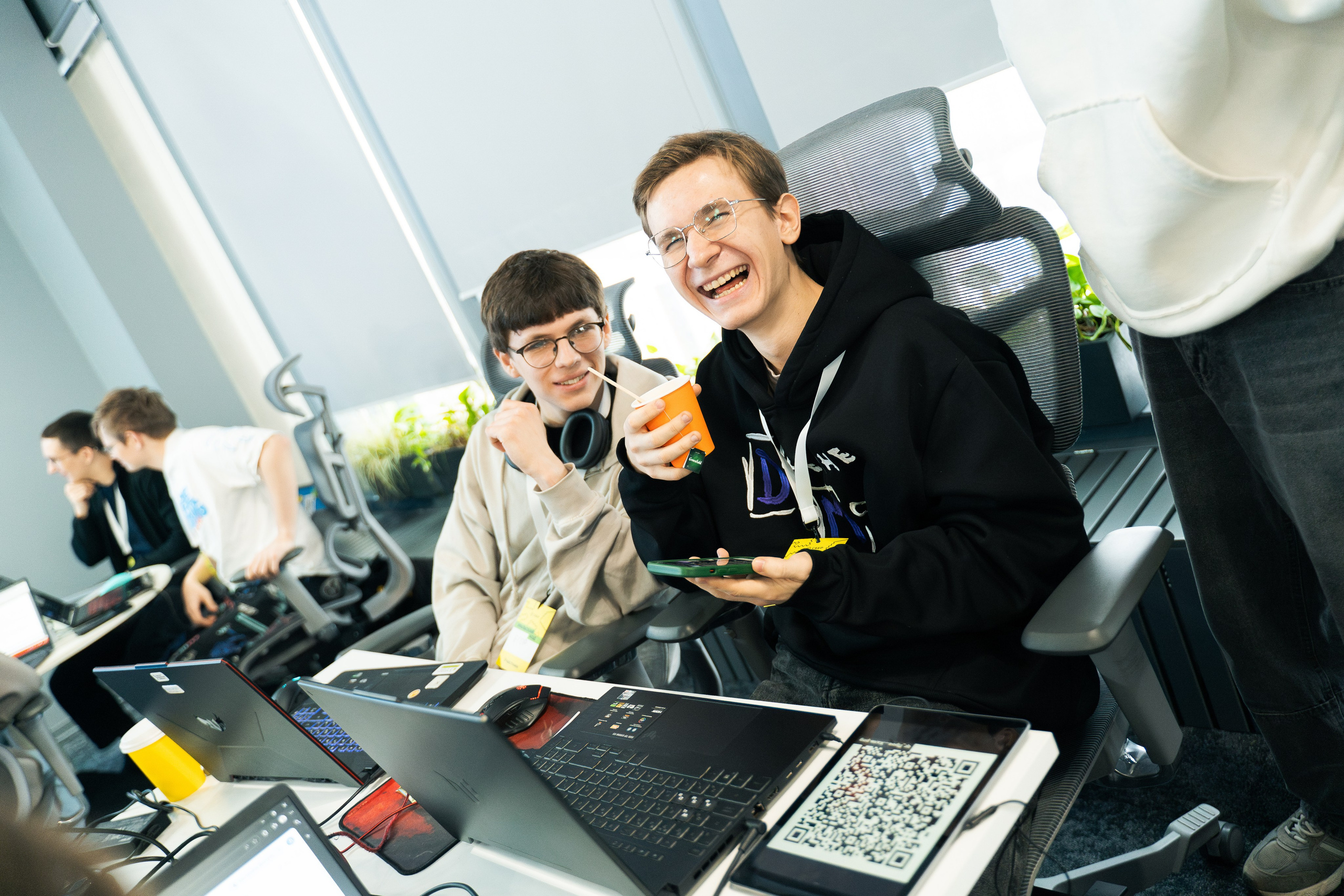 Команда разработчиков работает за ноутбуками и улыбается