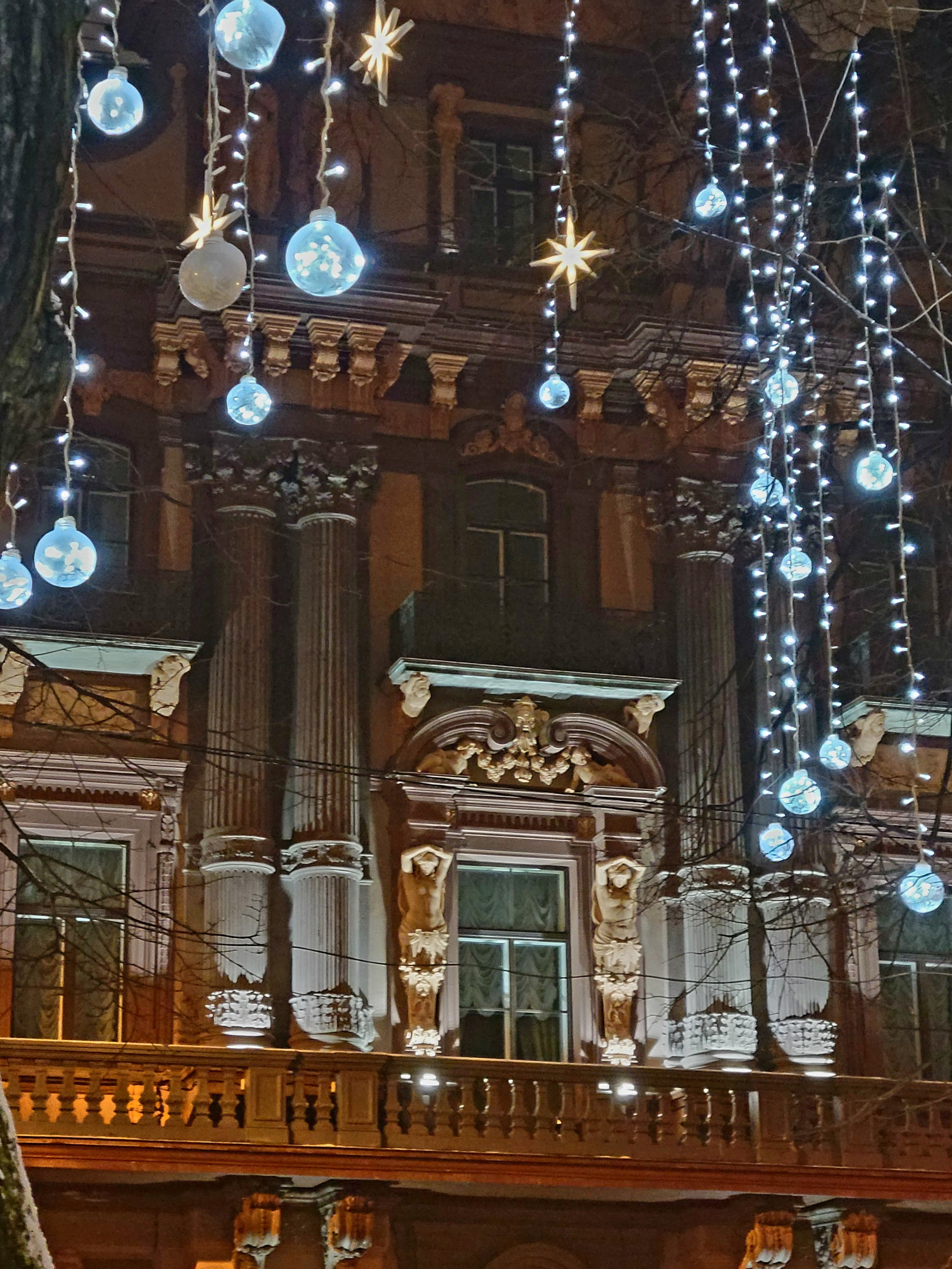 На крышах домов - снег и сосули, на деревьях - искусственные. Вечером становится очень красиво