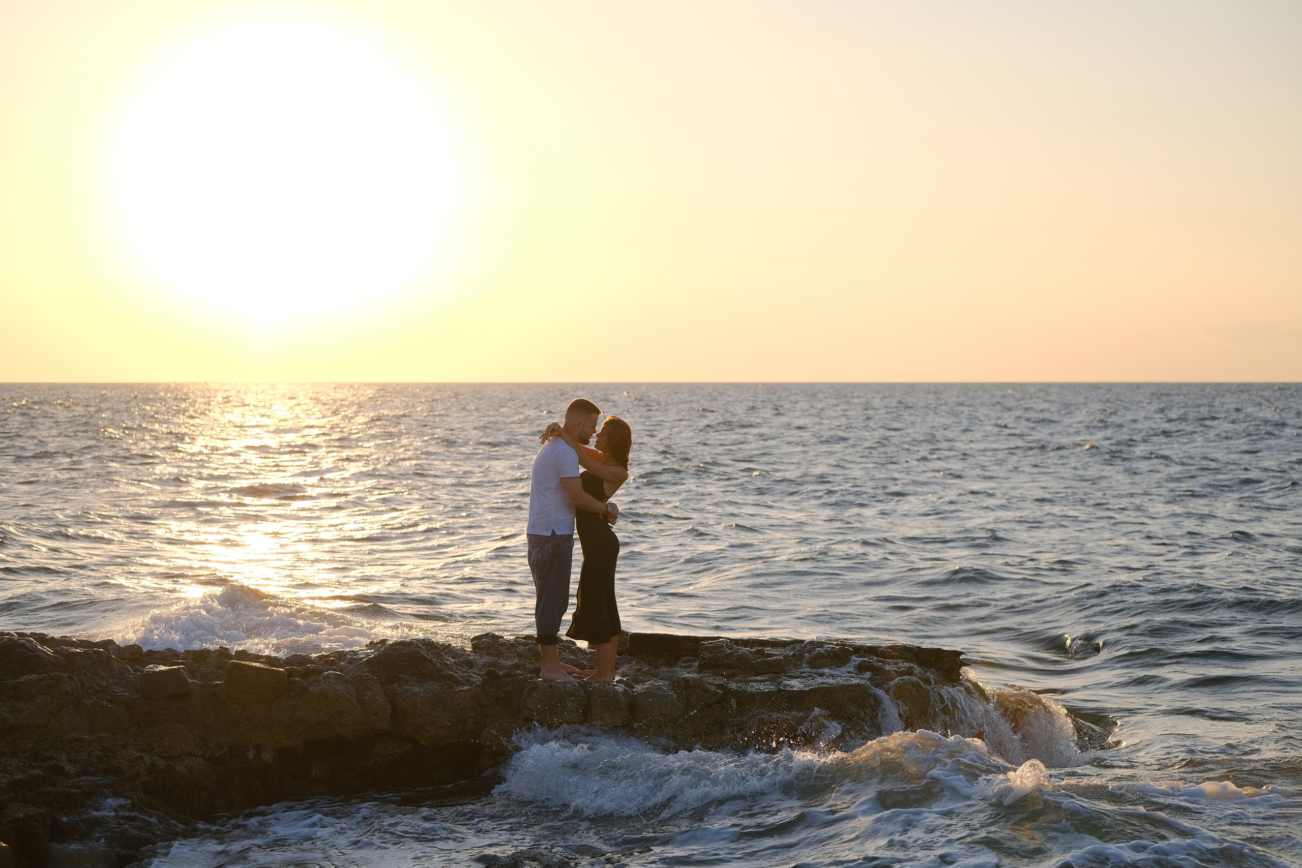Прекрасные ребята встречают закат на каменном пирсе у моря в Херсонесе Таврическом. Фотограф и видеограф Желдак Илья