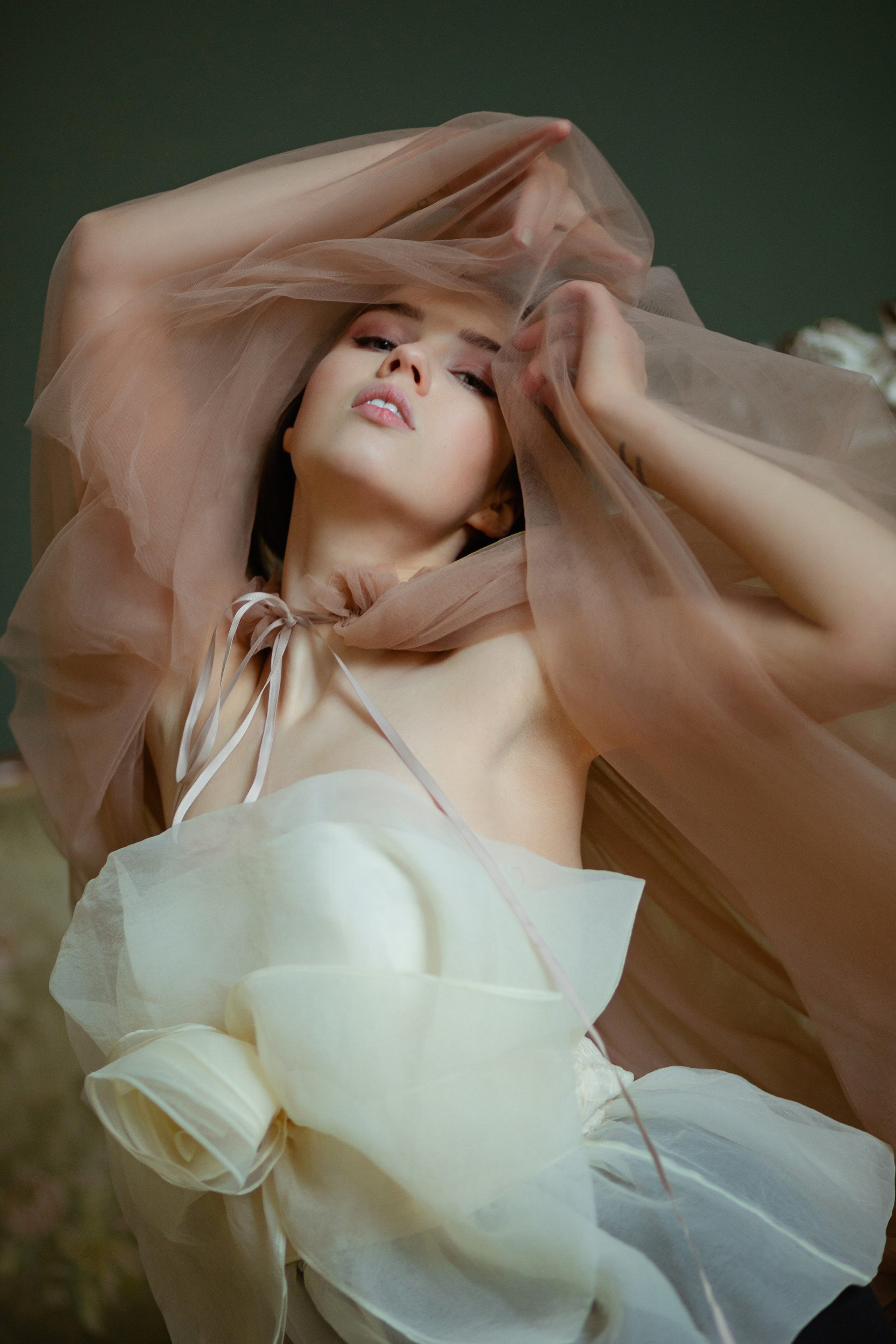 Нежная портретная фотосессия для девушки в постельных тонах
