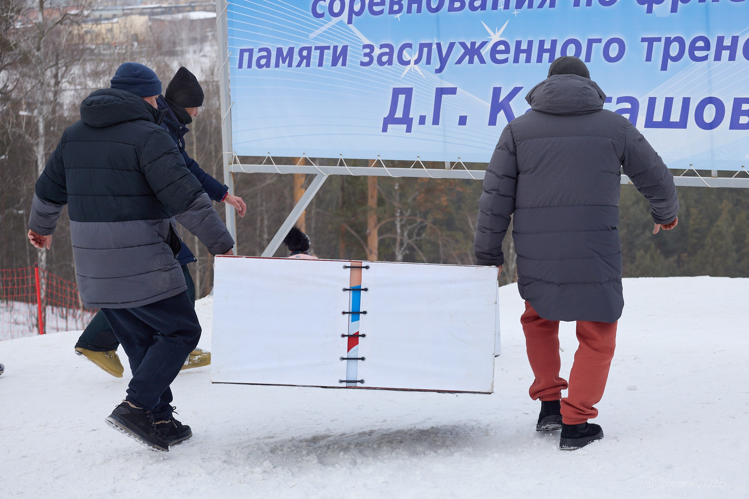 Мужчины устанавливают пьедестал для награждения.