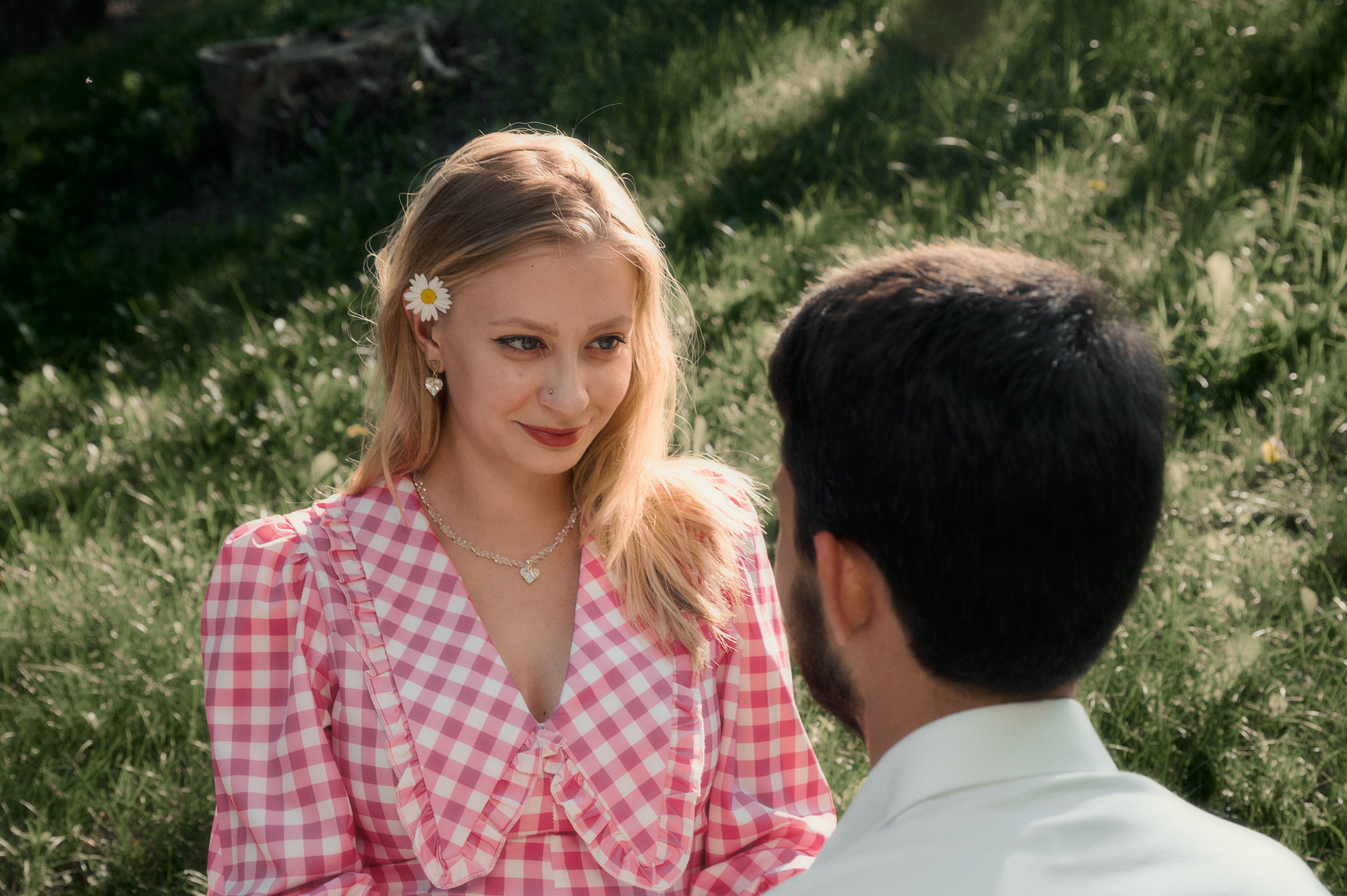 Елизавета в розовом платье в клетку смотрит вниз, рядом Юрий в белой рубашке.