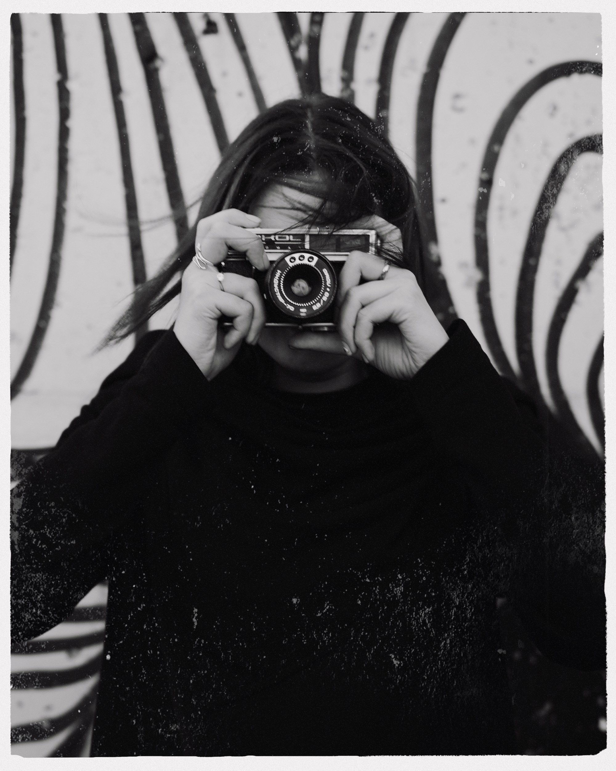 Девушка держит в руках старый фотоаппарат