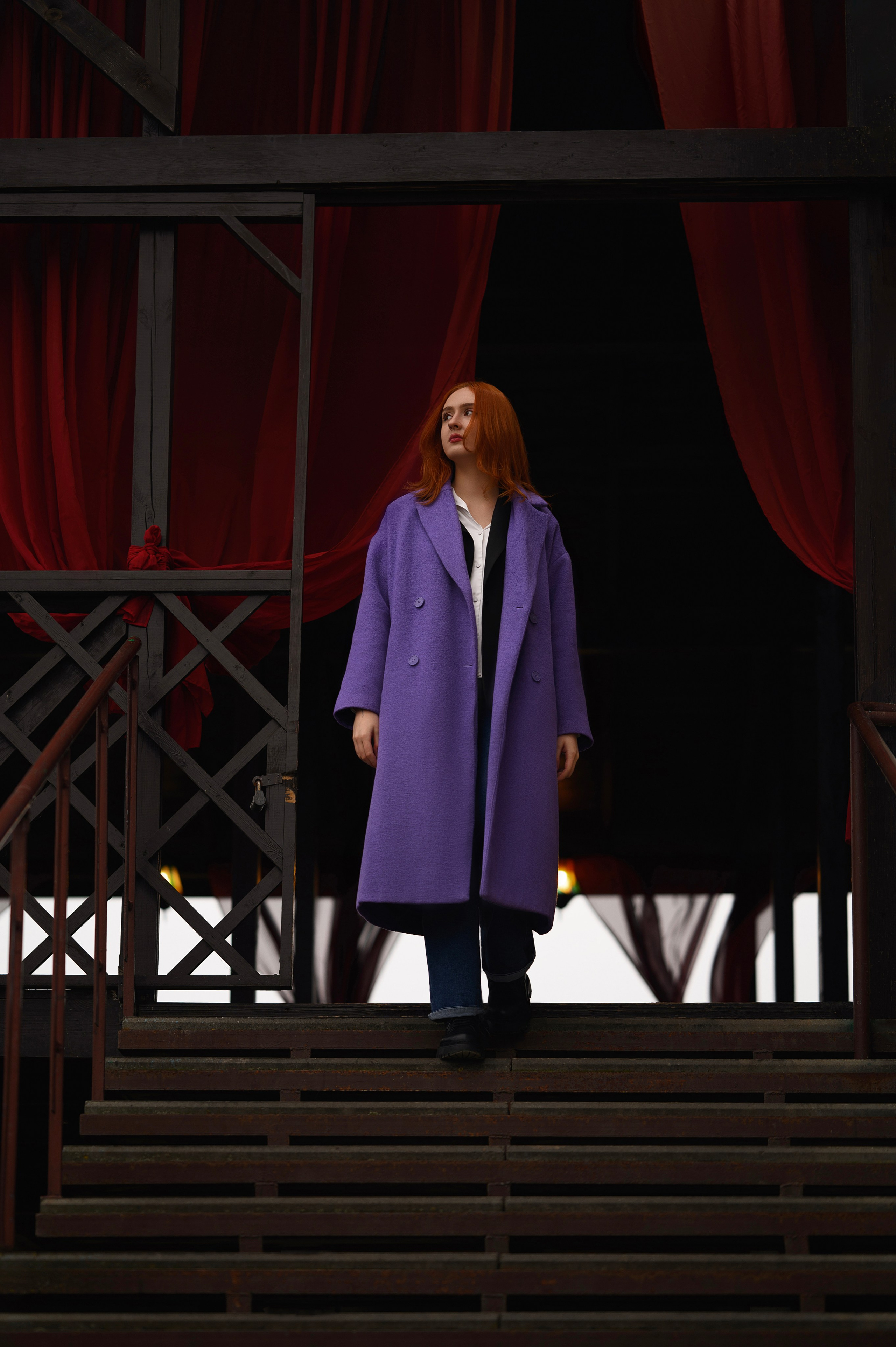 Елизавета Жуйкова (Волгодонск): съёмка на фоне здания. Модель в фиолетовом пальто, яркие рыжие волосы, красные шторы.