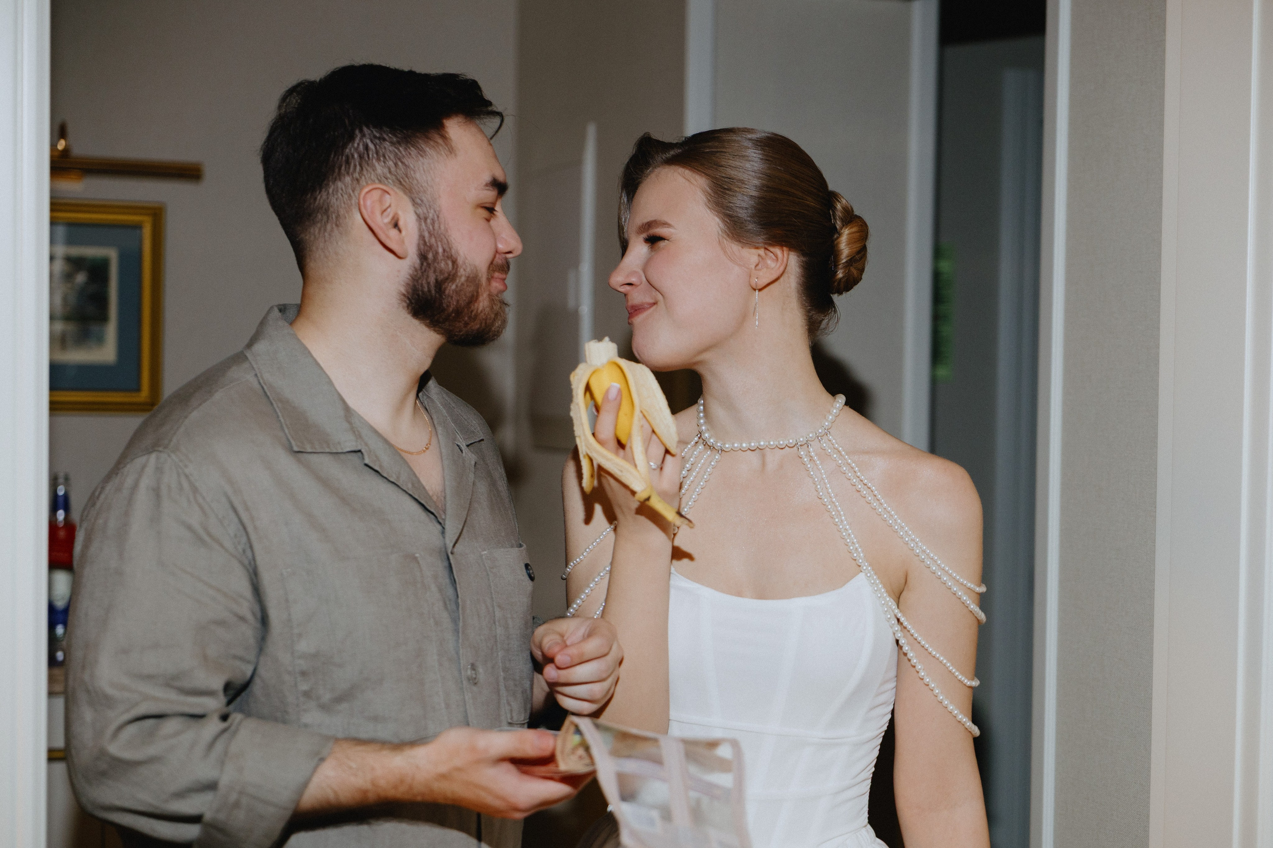 Жених и невеста смотрят друг на друга, а невеста ест банан.