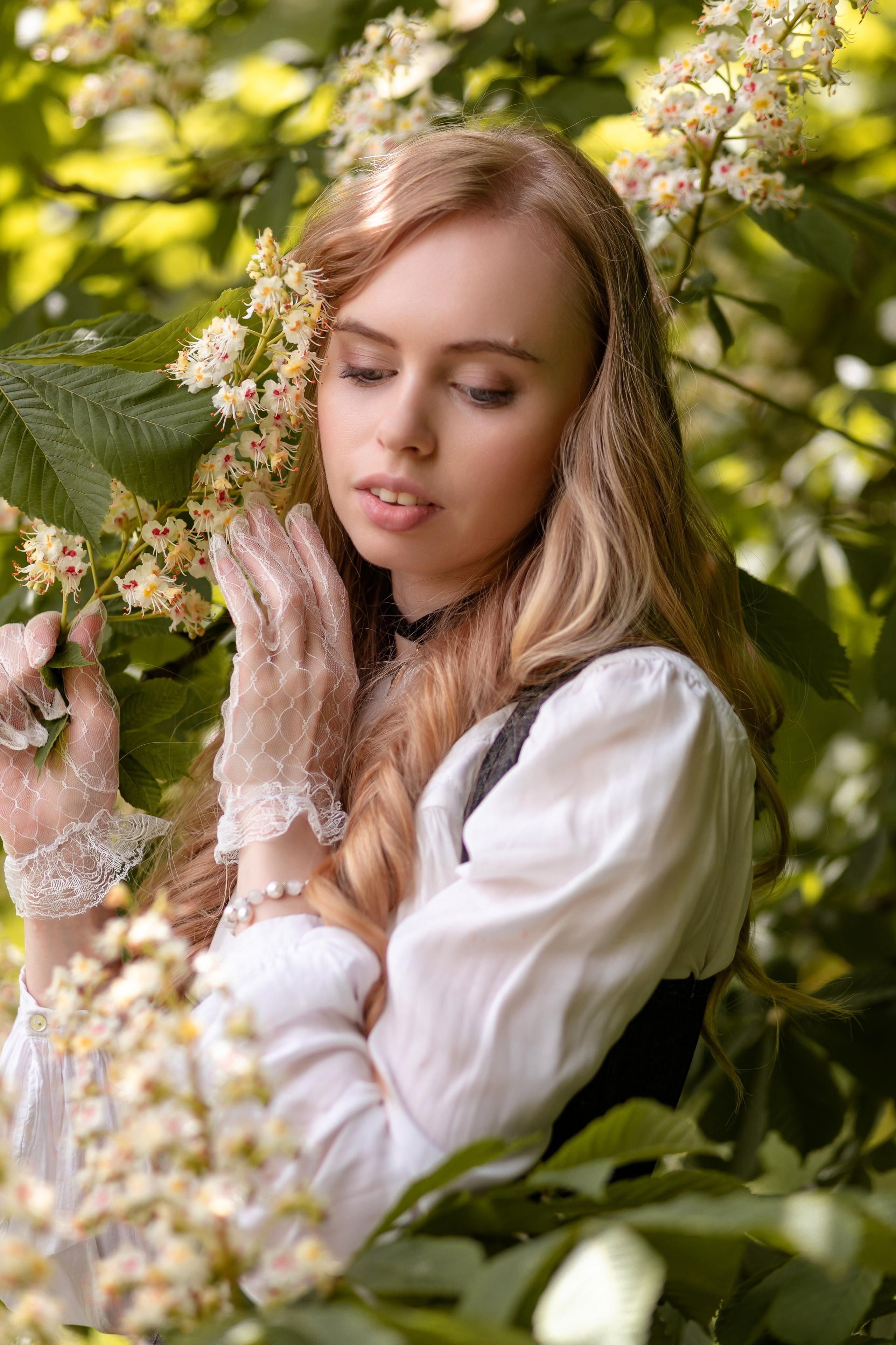 Портрет милой девушки среди цветущих веток каштана