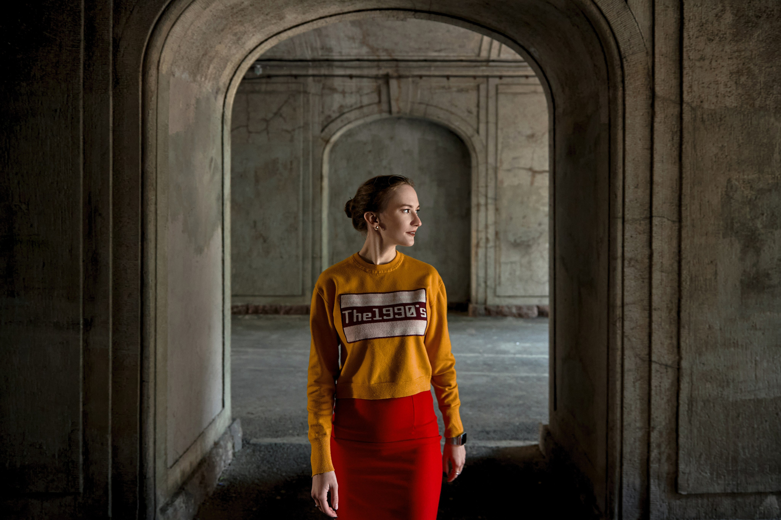 девушка в ярком образе в арке дворов Петроградской стороны