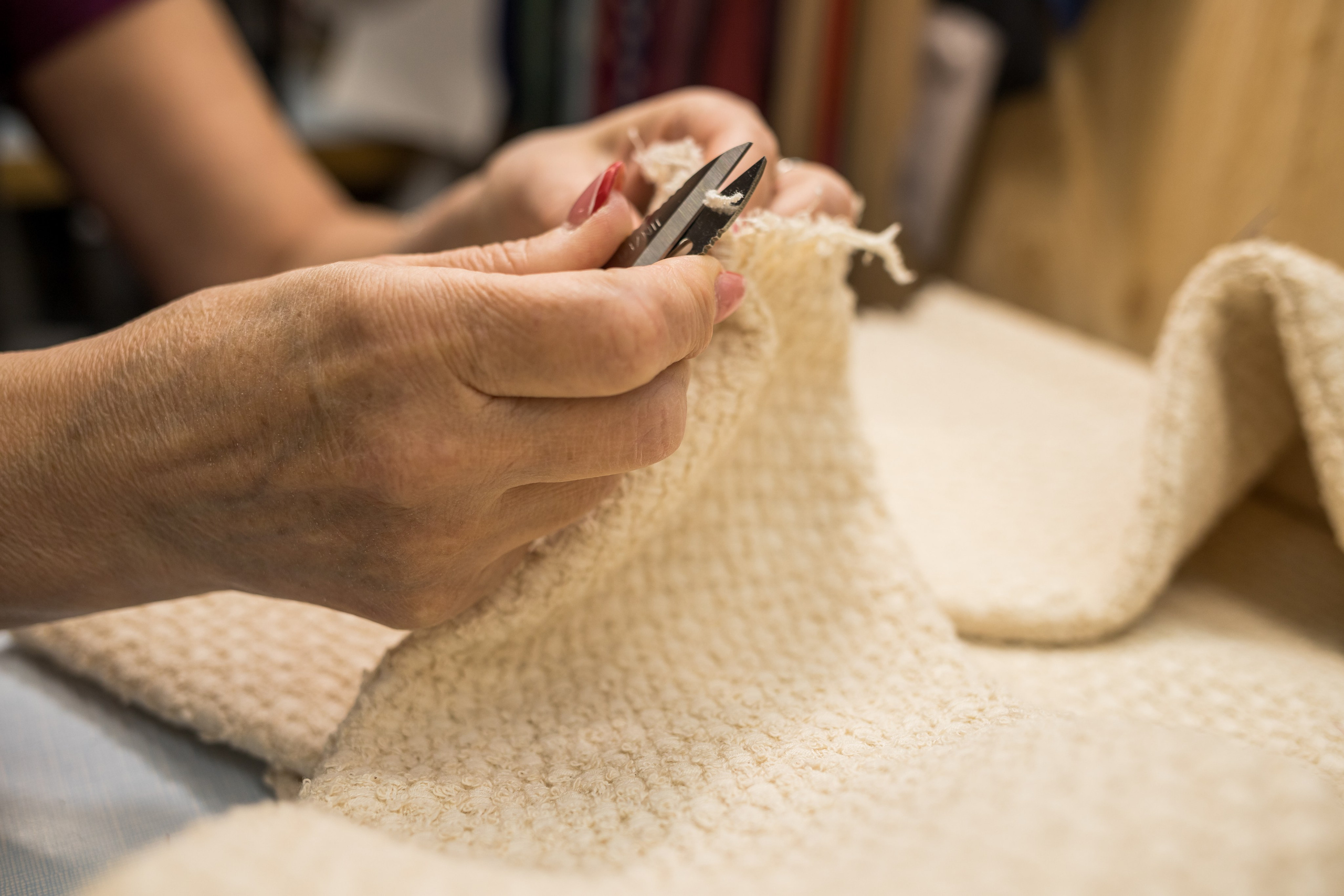 Руки мастера обрезают нить на буклированной ткани, ателье Natalia Chevdar, Екатеринбург, фотограф Илья Антропов