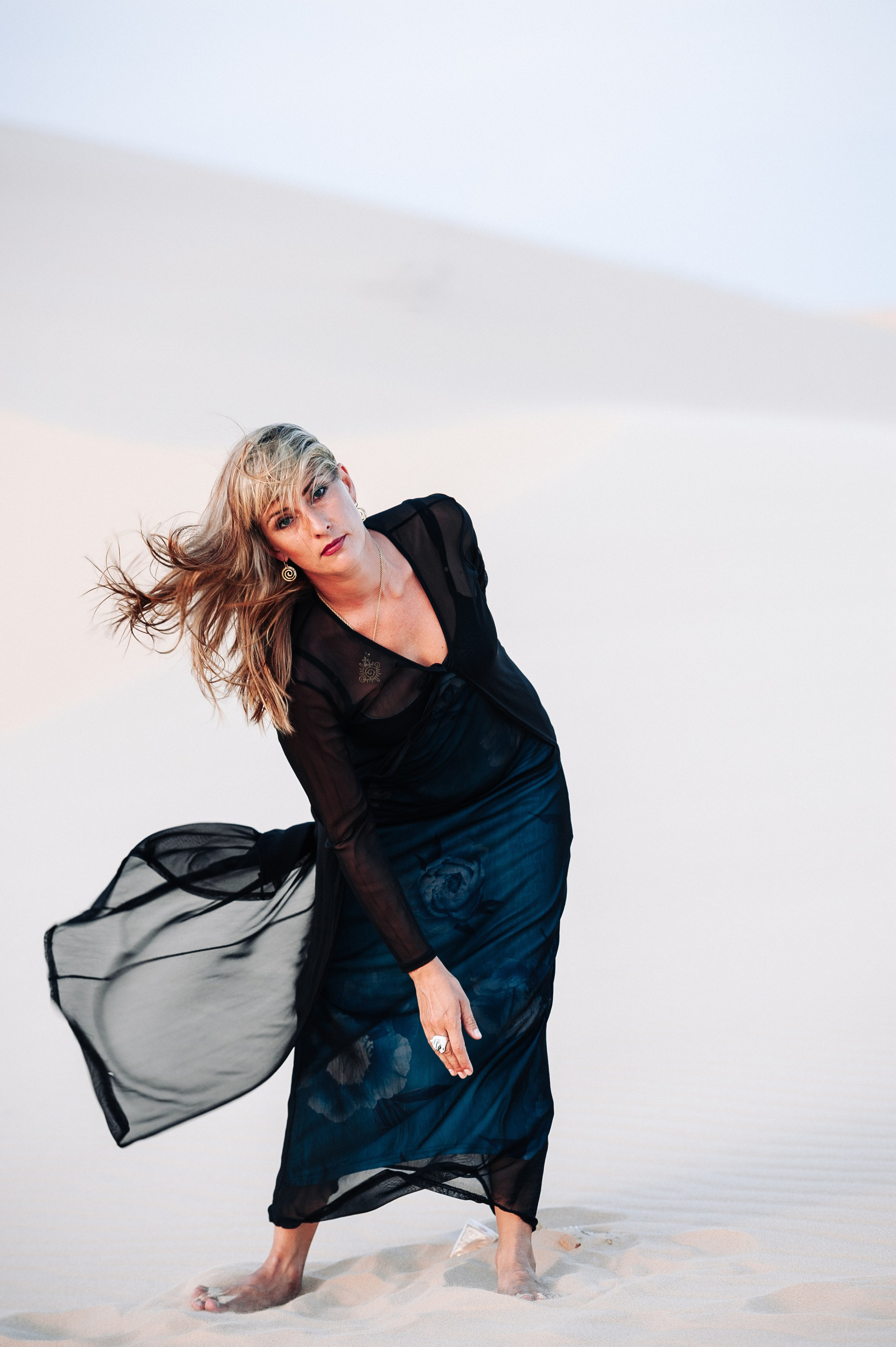 фотосессия девушки в черном длинном платье в дюнах Муине, Вьетнам на закате