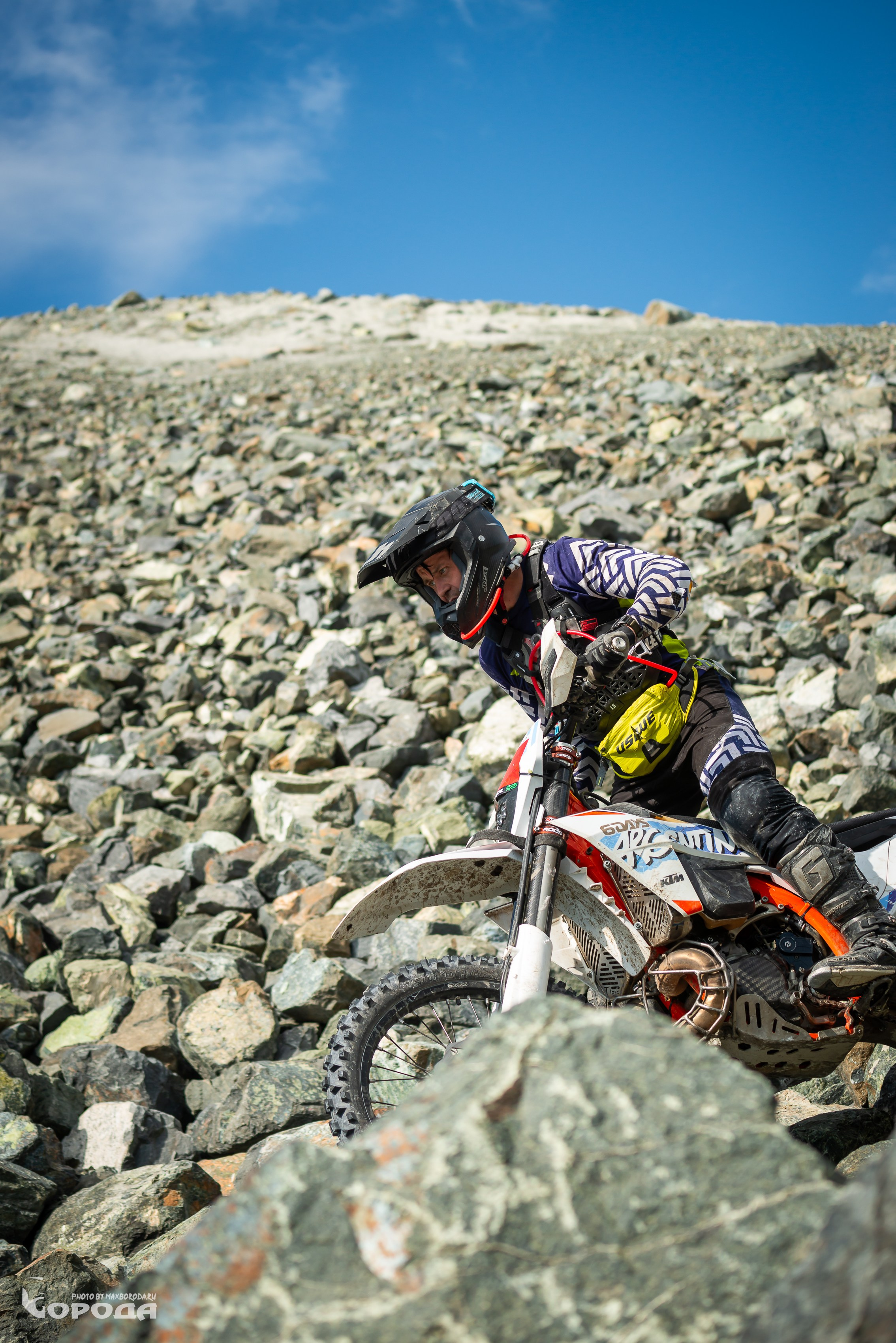 Эндурист в защитной экипировке преодолевает каменистую трассу на мотоцикле KTM.