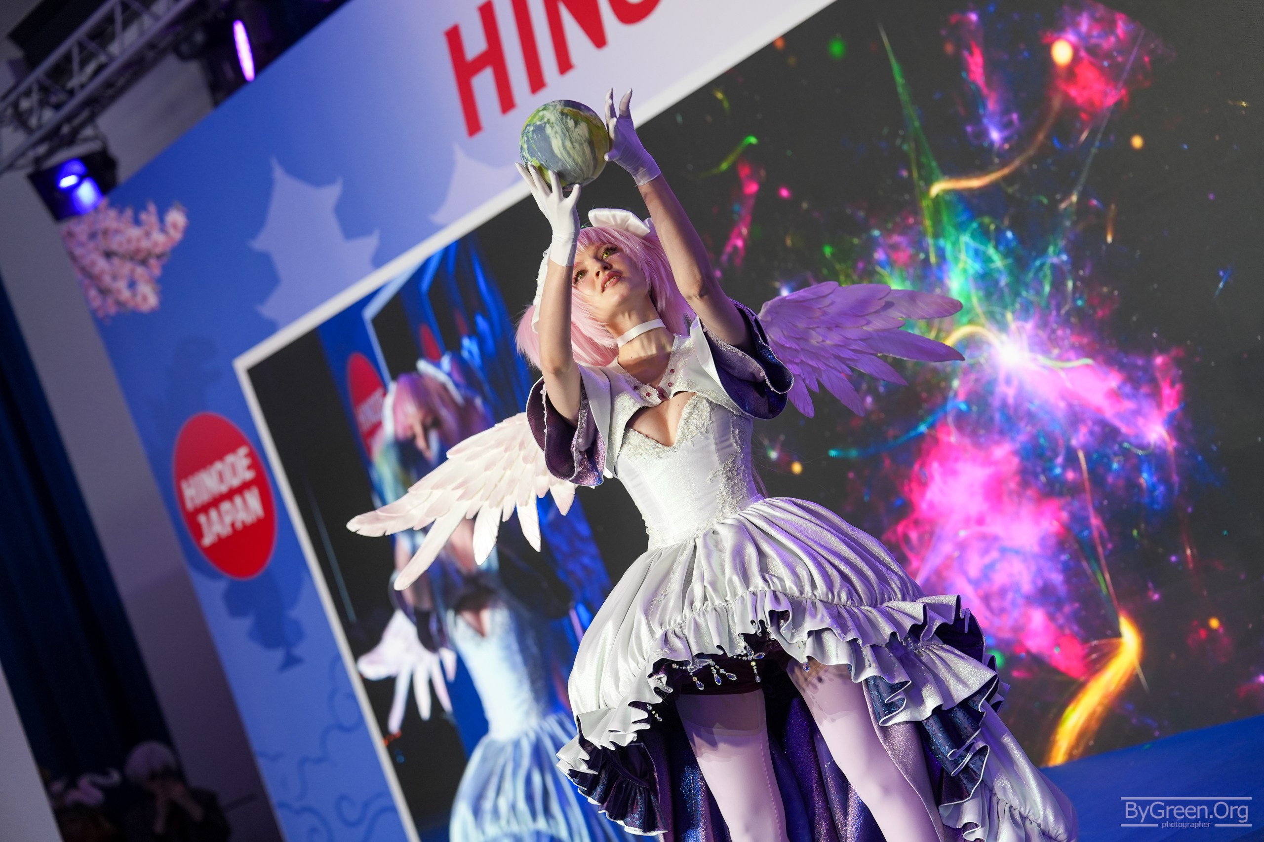 Cosplay of Ultimate Madoka from Madoka Magica — wings and white gown mid-spin, Hinode 2026, Moscow