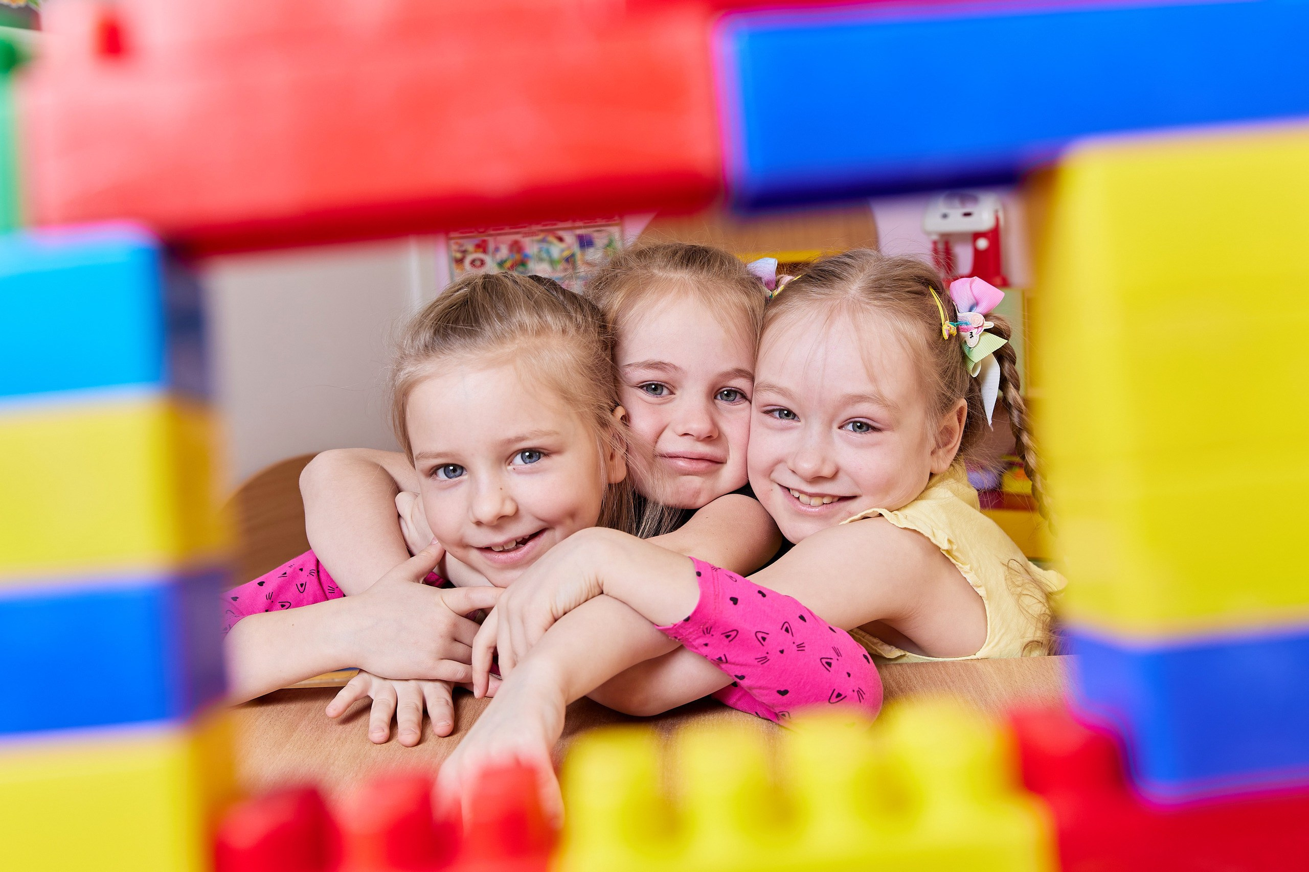 три подружки радостно смотрят через цветную рамку