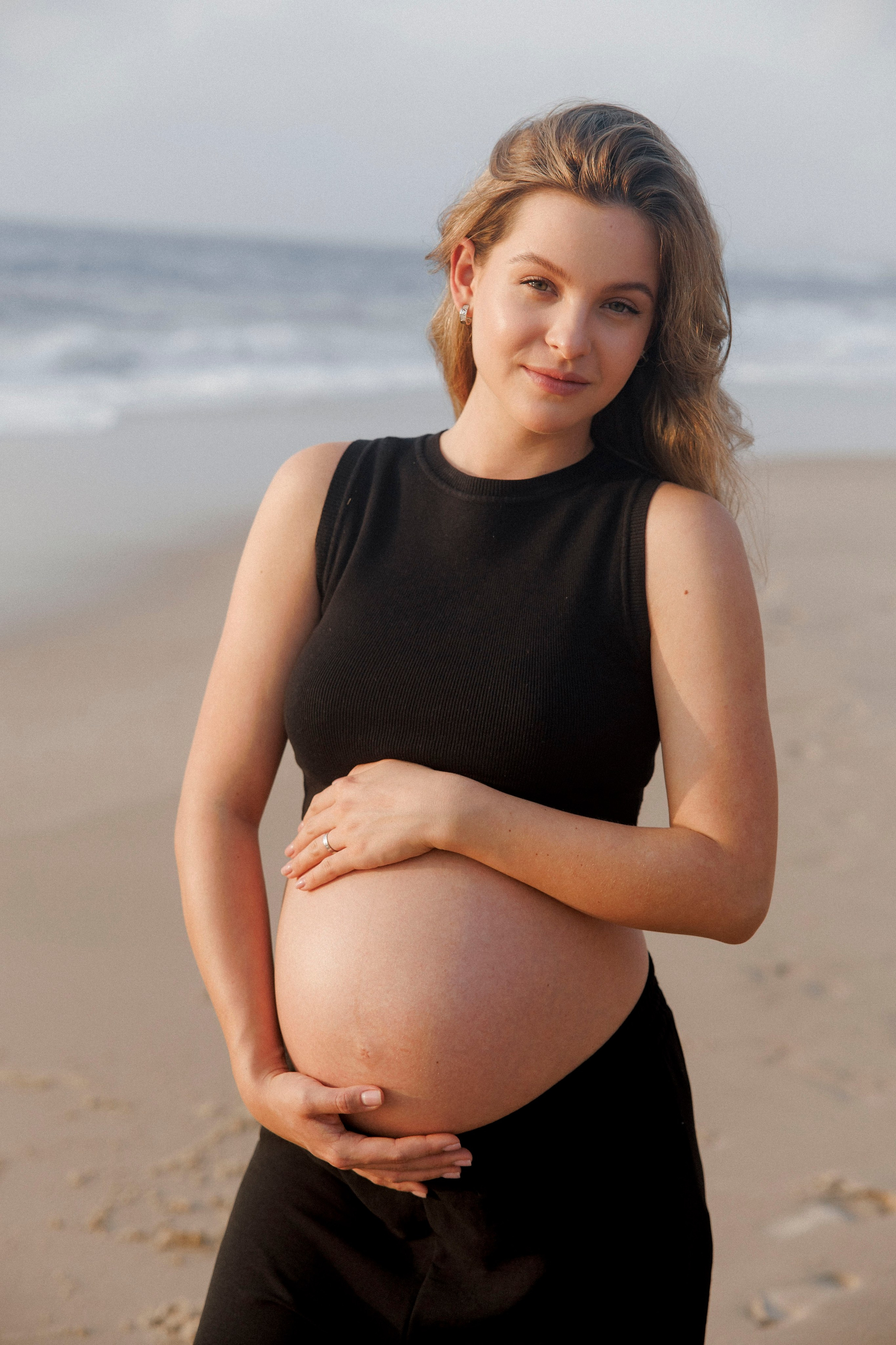 Pregnancy photoshoot near the sea (cloudy weather). Главная