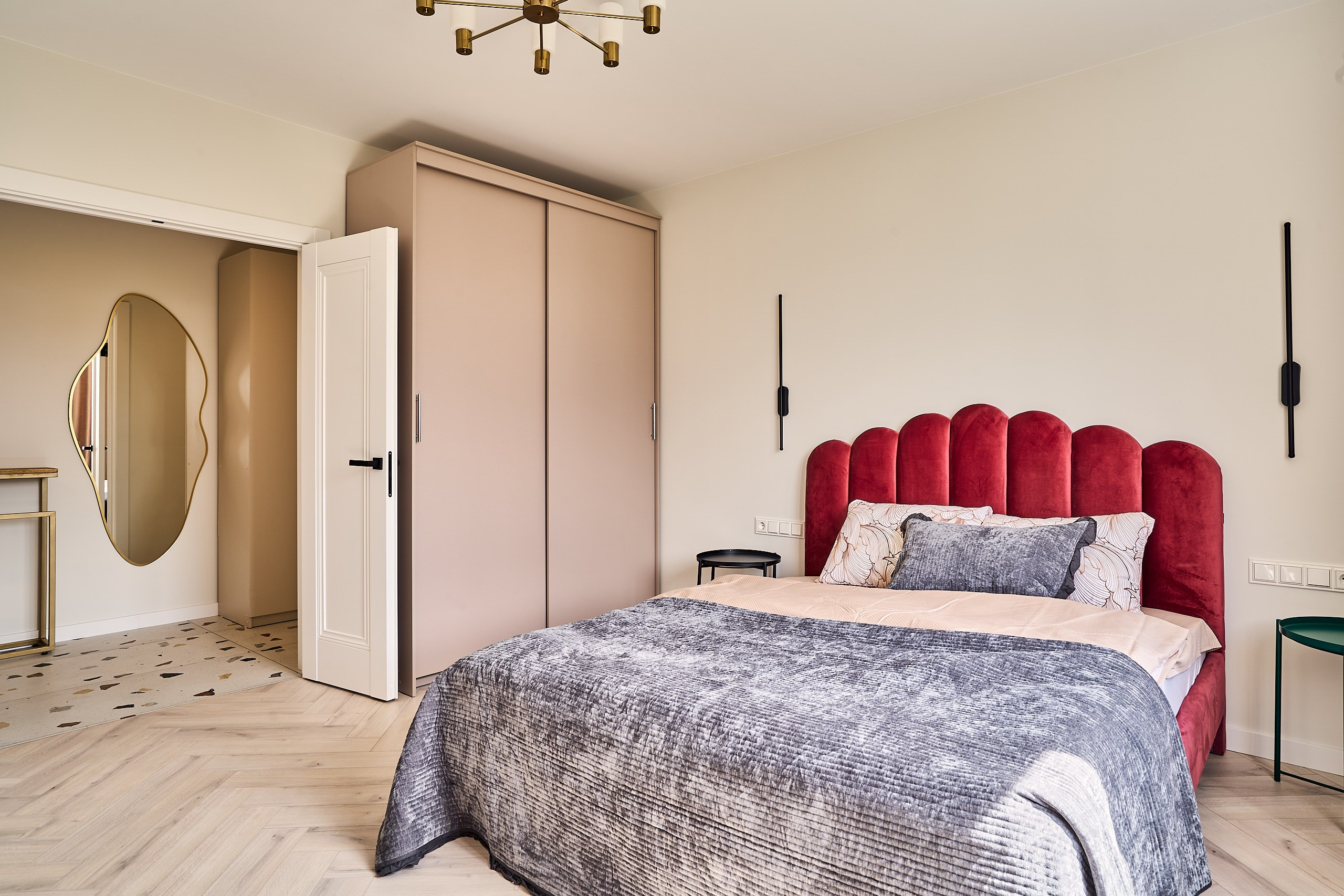 Интерьерная фотография спальни с общим планом на кровать, шкаф и открытую дверь в коридор