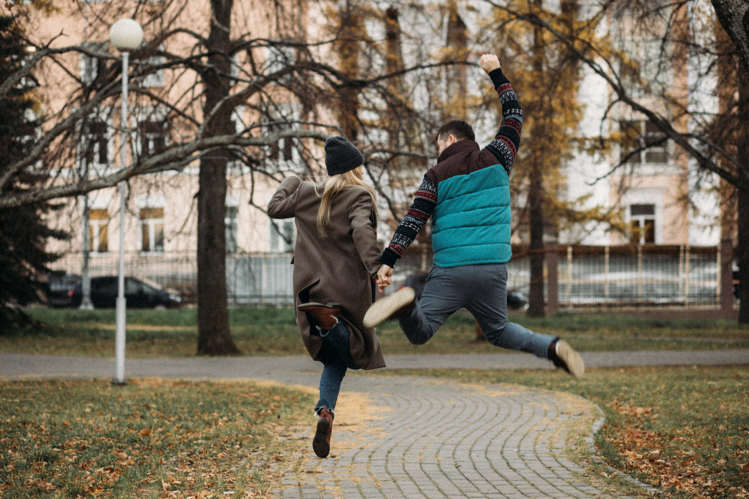 Закат осени отражается в глазах молодого парня и юной леди, бегущих по мосткам Петровского парка в Архангельск, заснятые выдающимся фотографом Алексеем Клещиновы