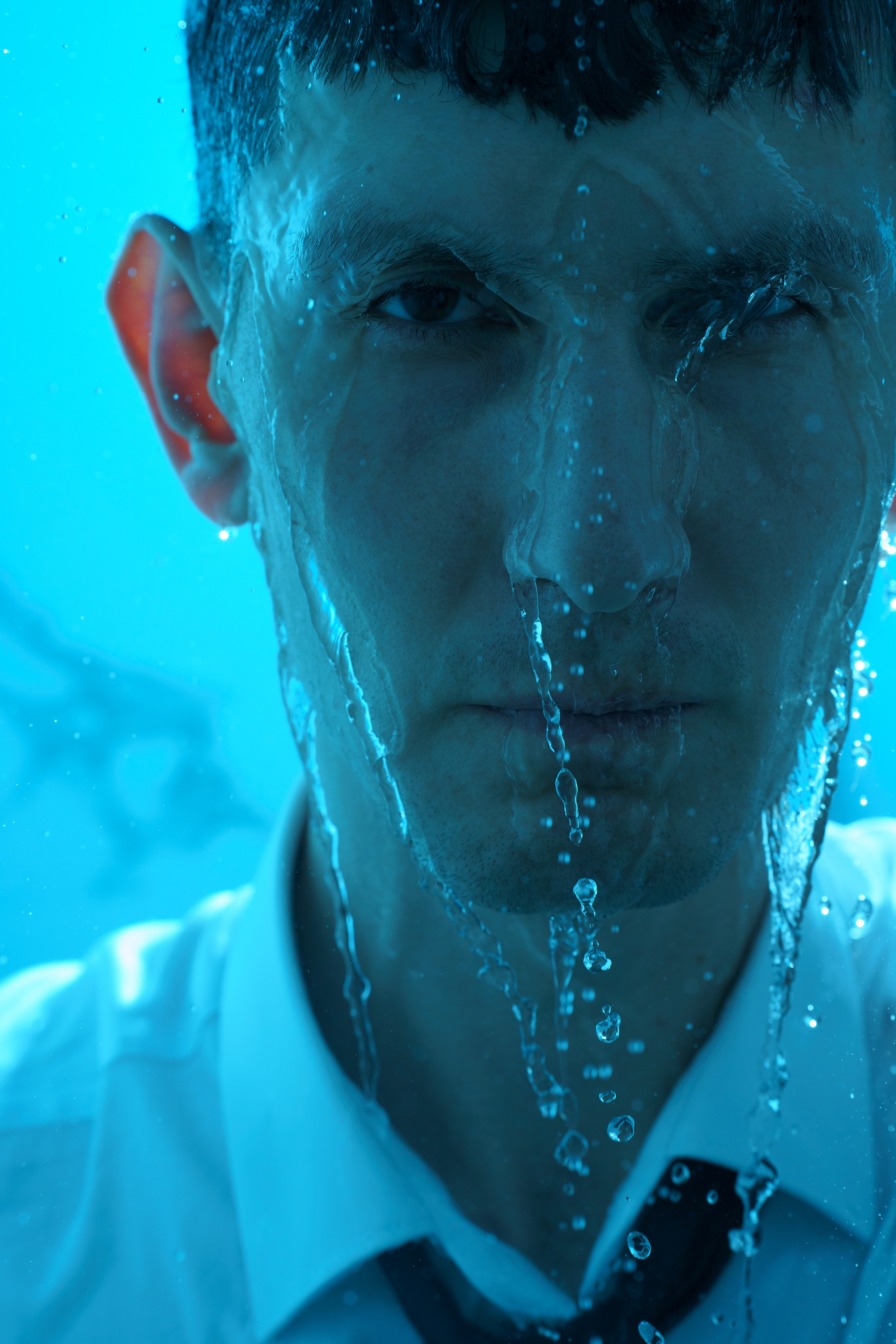 Крупный портрет мужчины под струями душа, эмоциональный автопортрет в фотосессии