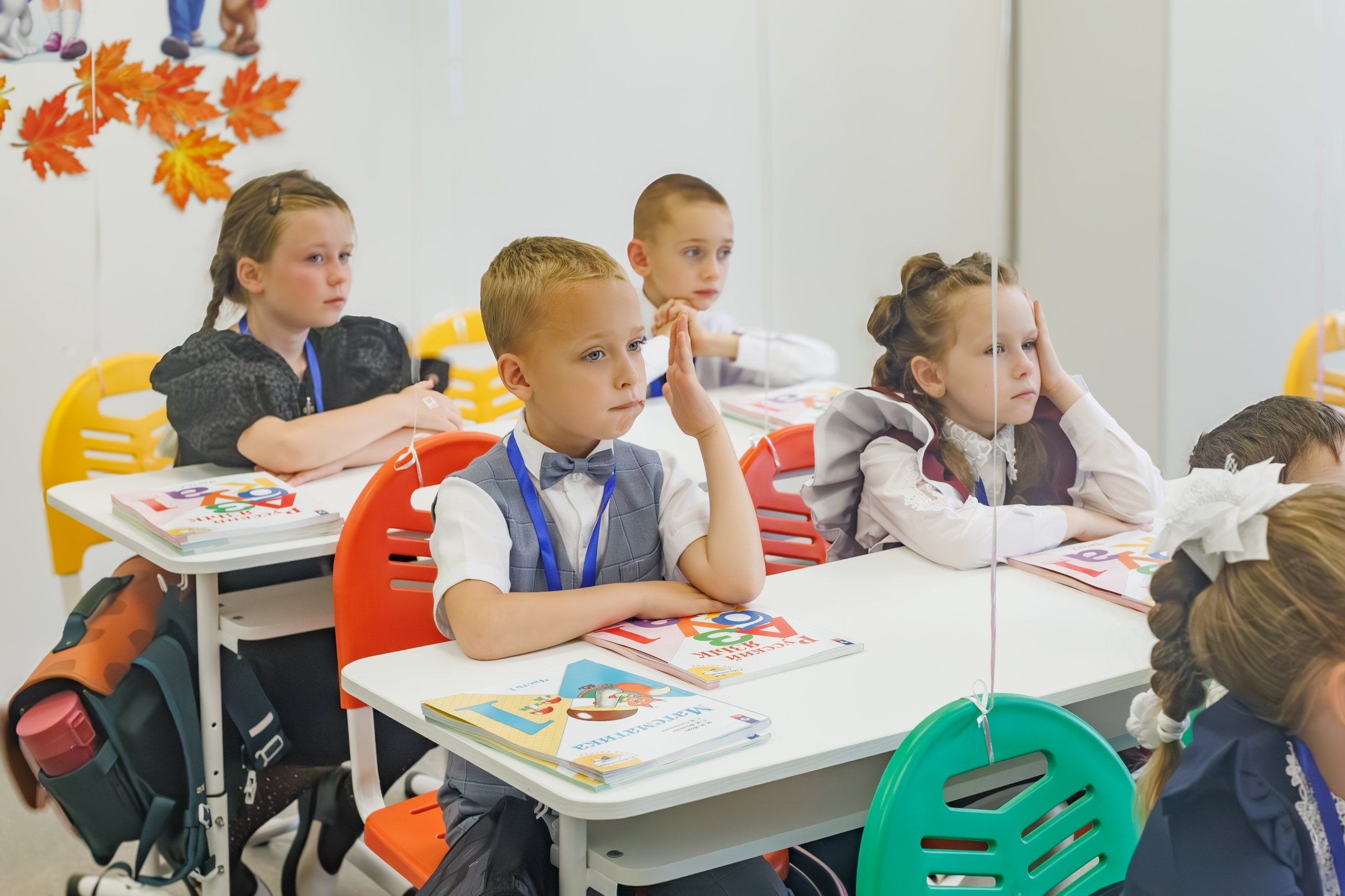 Дети сидят за партами в классе, первый урок в День знаний