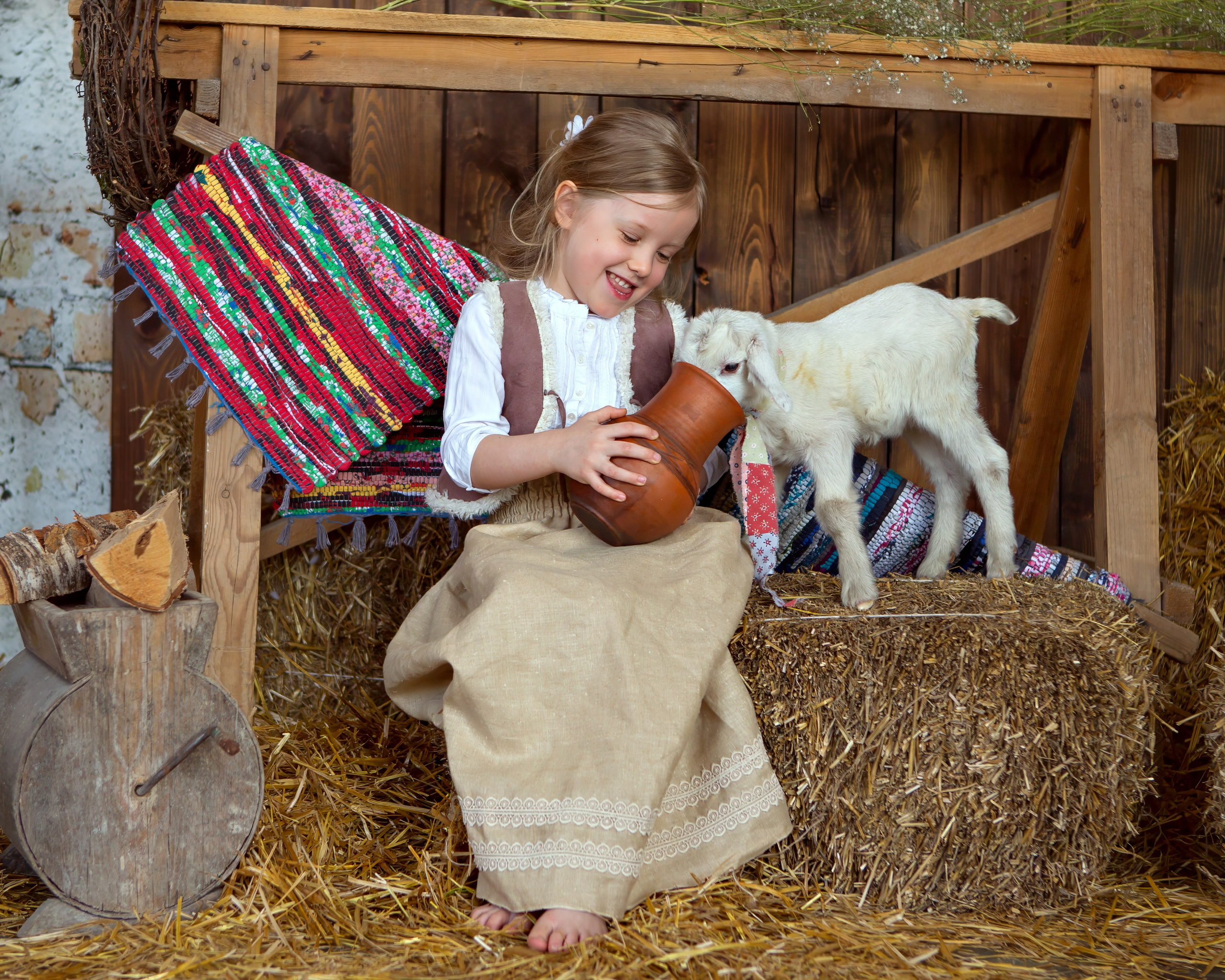 Девочка кормит козленка молоком
