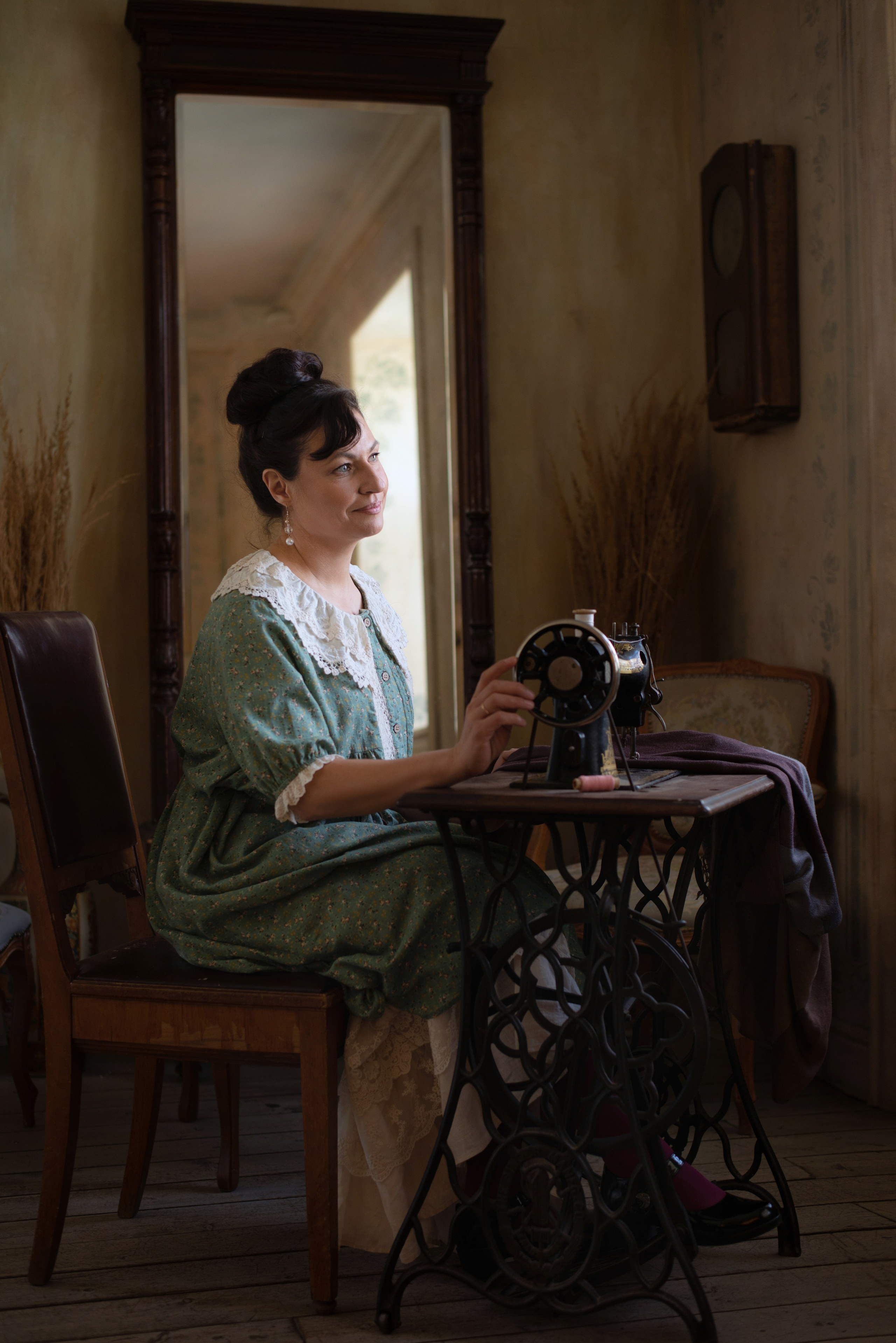 Фотопортрет женщина в ретро образе в интерьере начала XX шьет на машинке