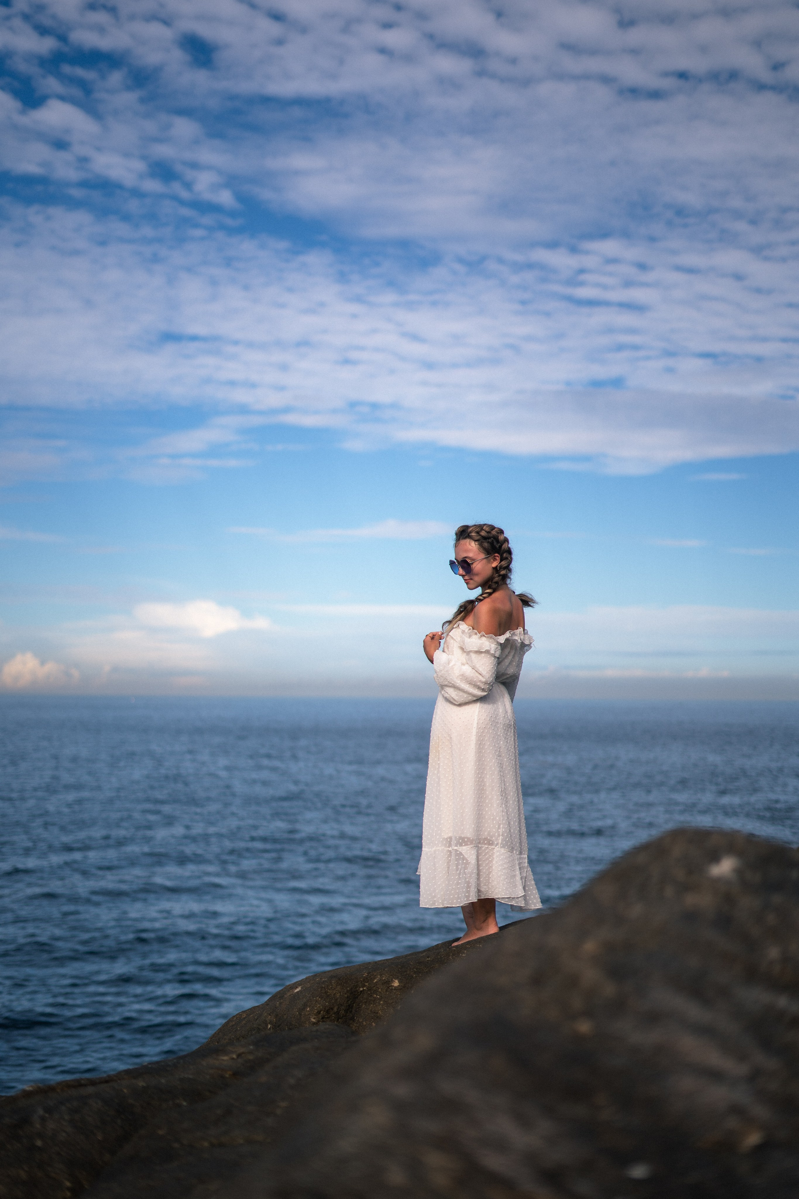 a young girl in a white dress and glasses surrounded by ocean waves