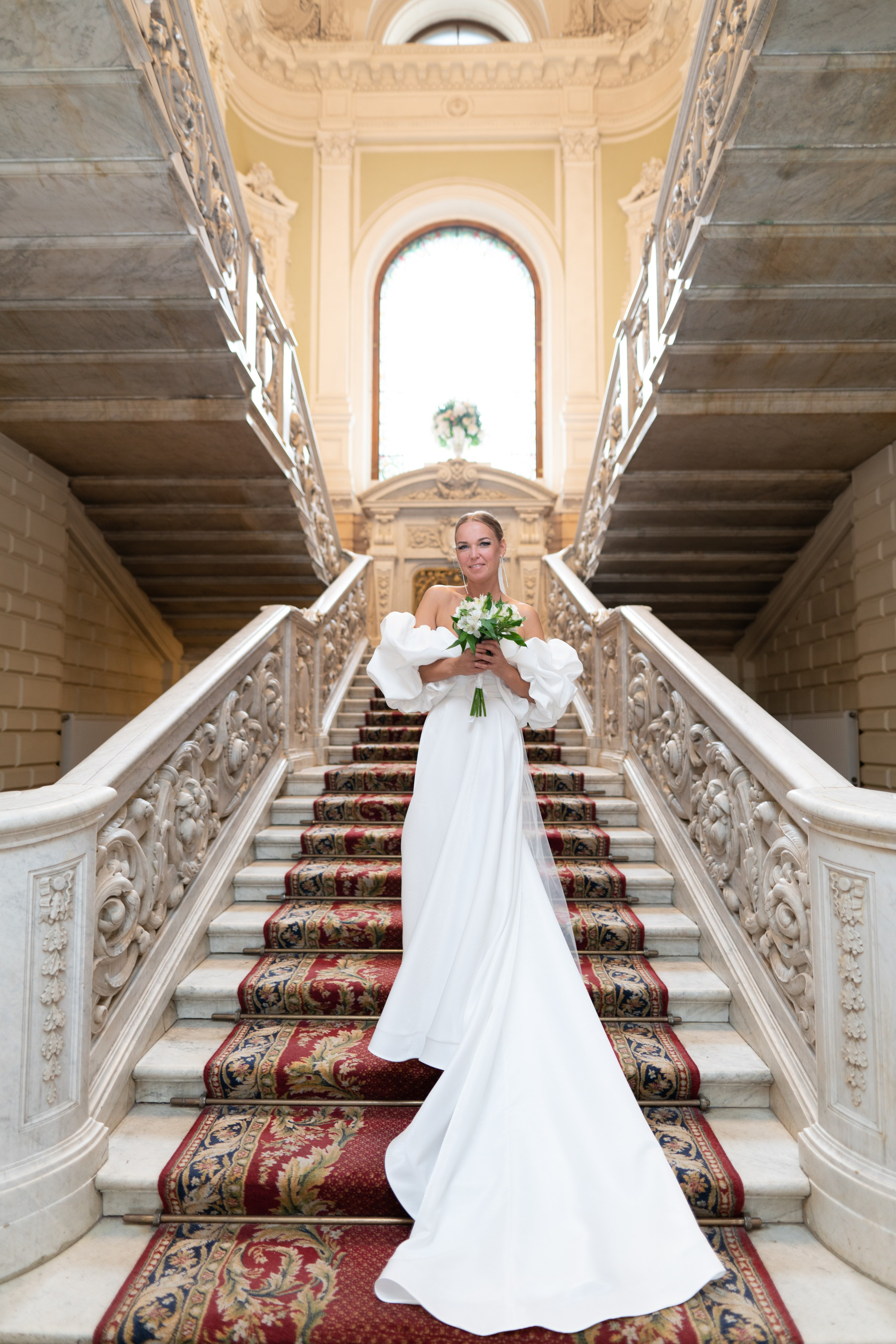 невеста стоит на ступеньках парадной лестницы дворца №1 Бракосочетания в Санкт-Петербурге.