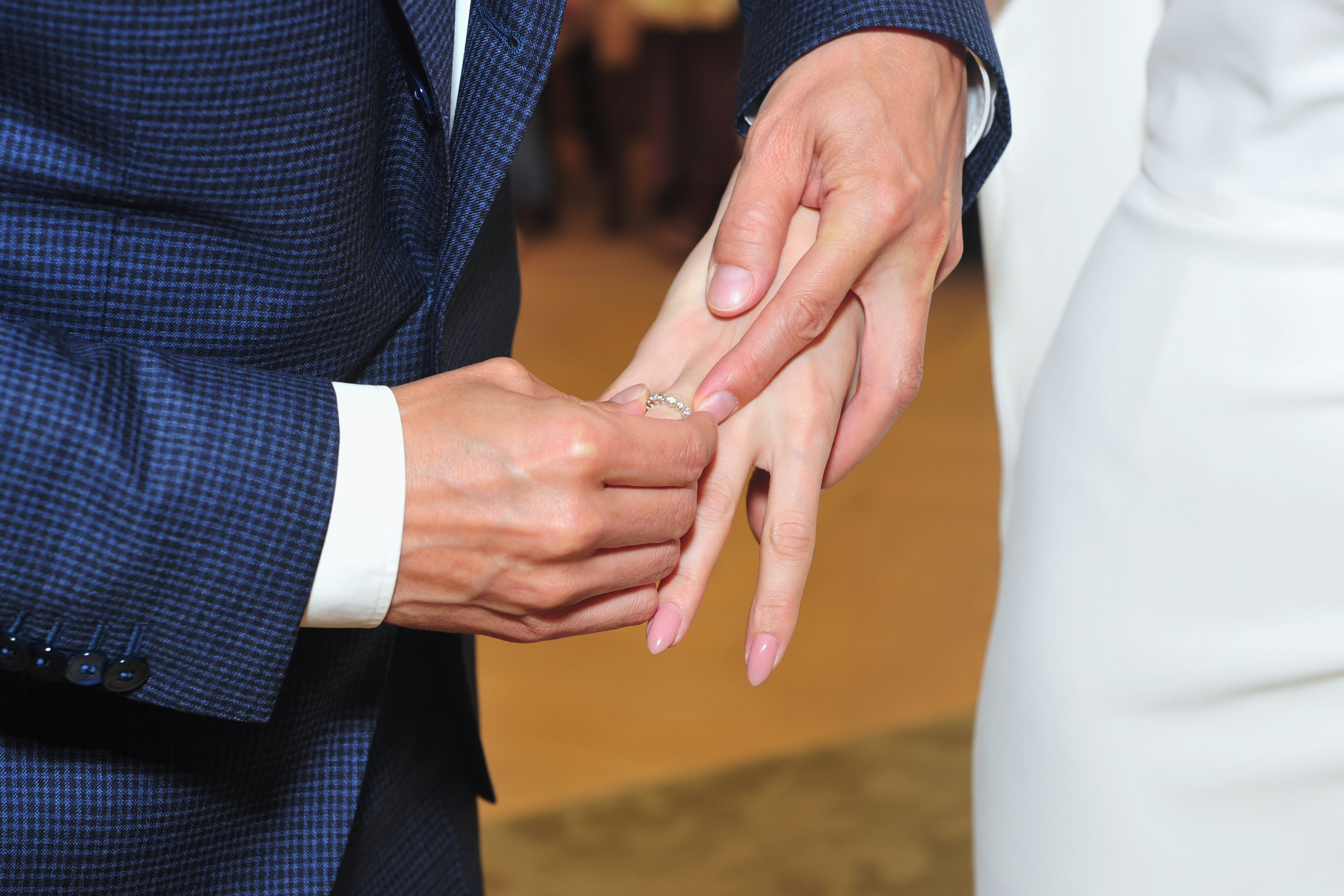 Роспись в ЗАГСе Барвиха Luxury Village летом, жених надевает обручальное кольцо невесте на палец