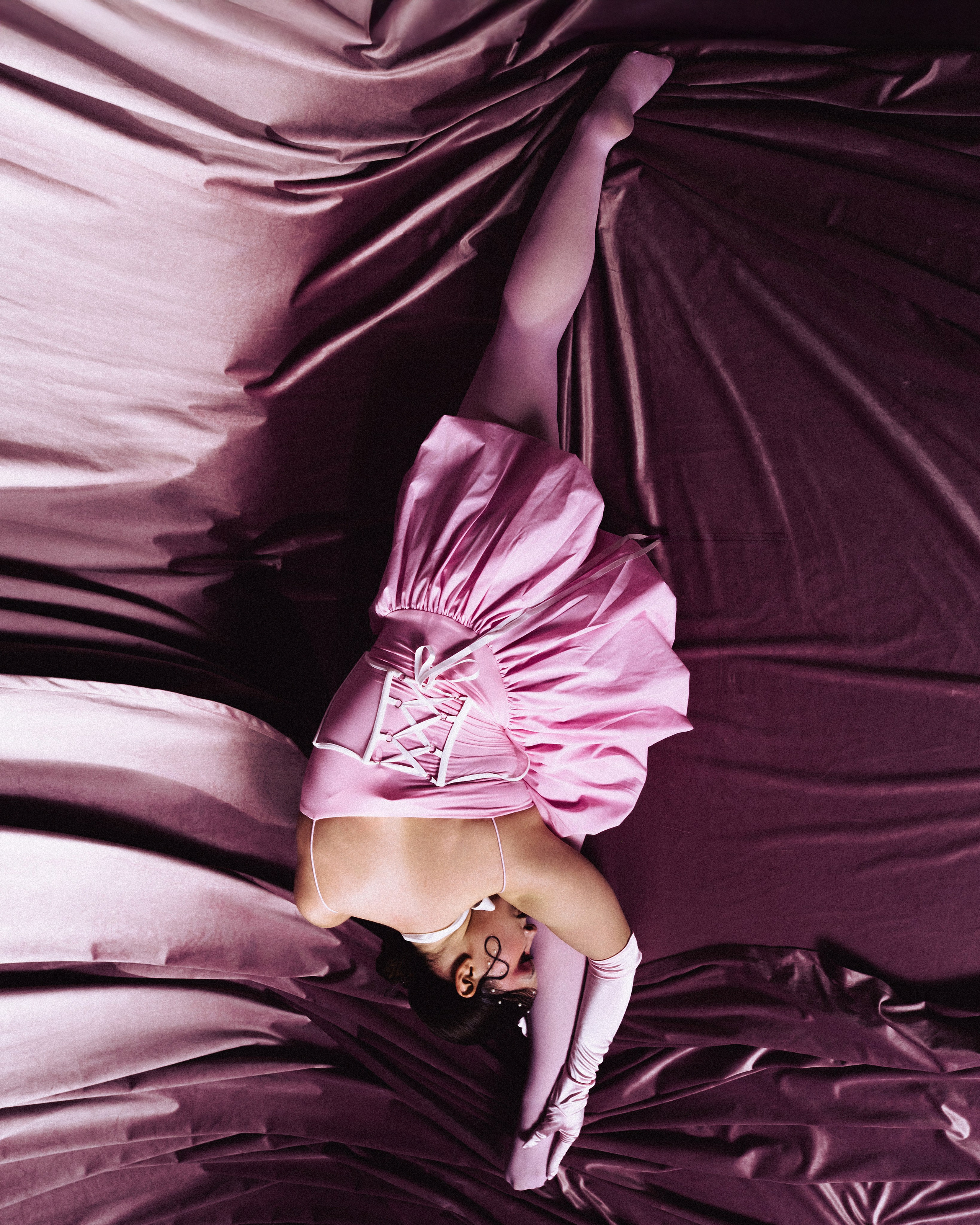 Фотограф Александра Овечкина Пенза: вертикальный кадр с перевернутой фигурой модели, розовый бархат и жесткие тени.