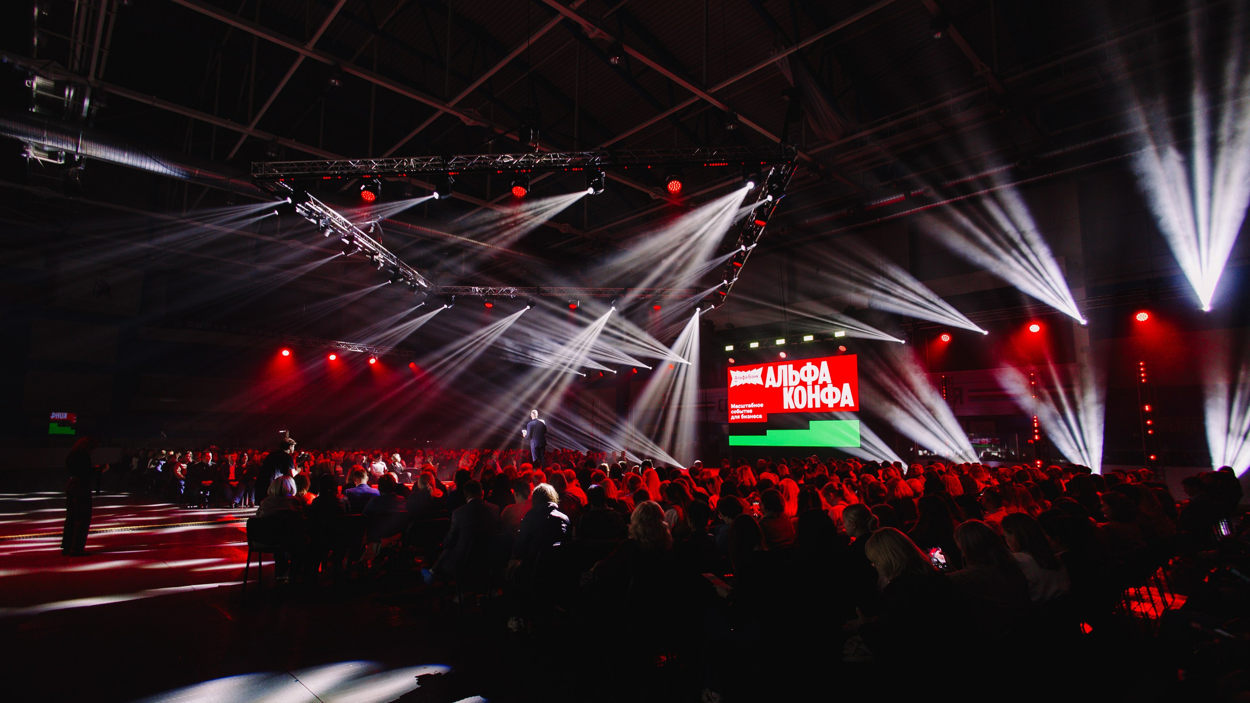 Общий вид зала: Широкий план площадки с сотнями зрителей и динамичным световым оформлением.