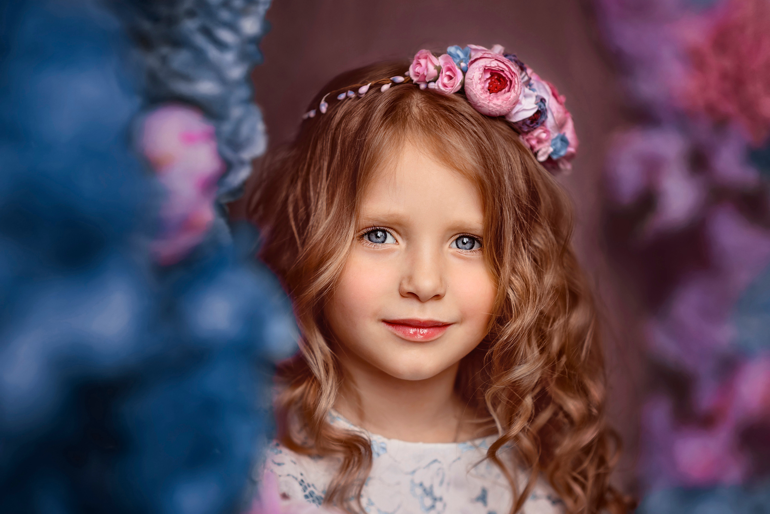 Девочка с цветочным венком на голове в весеннем студийном фотопроекте.