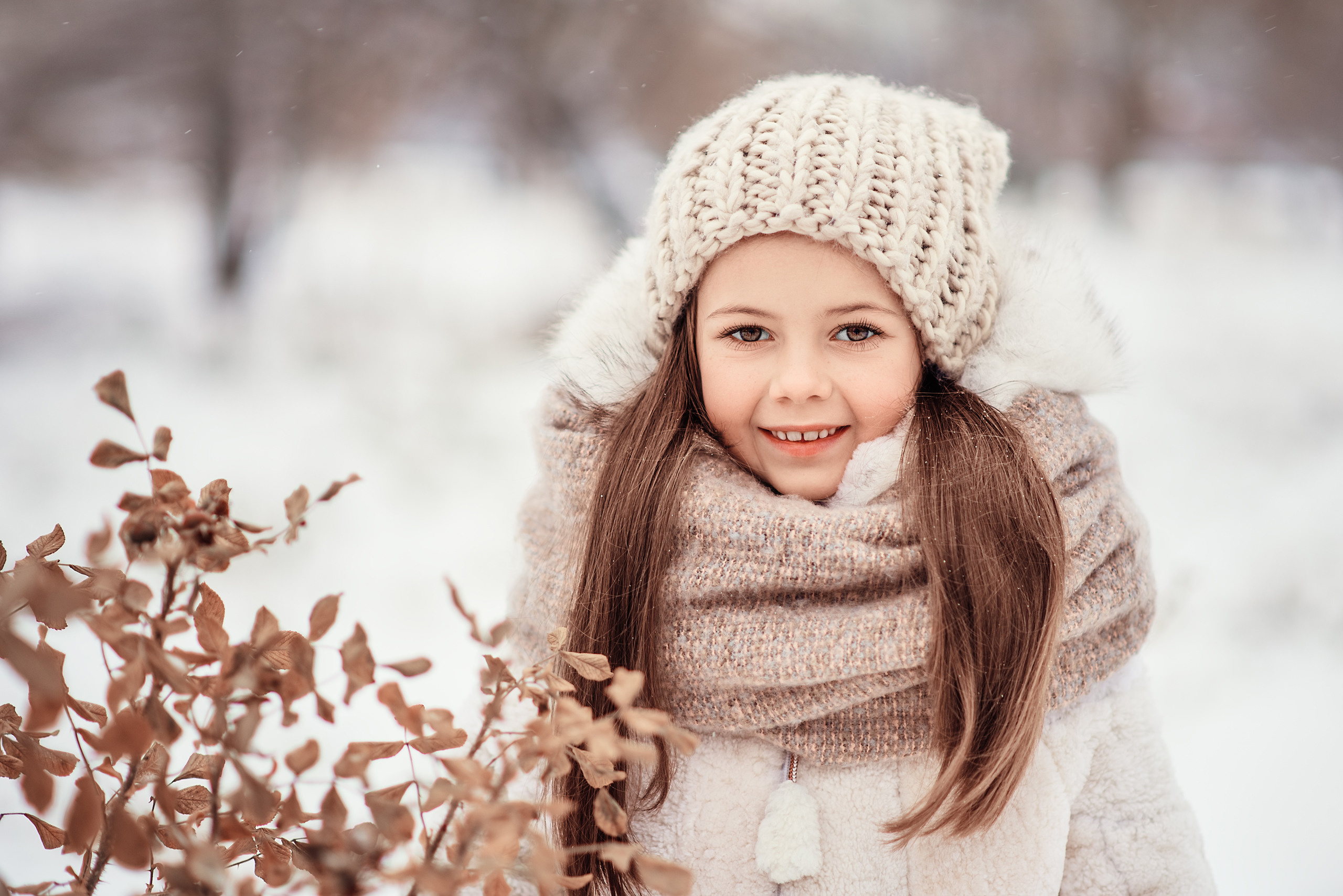 Крупный портрет девочки на фоне зимнего пейзажа.