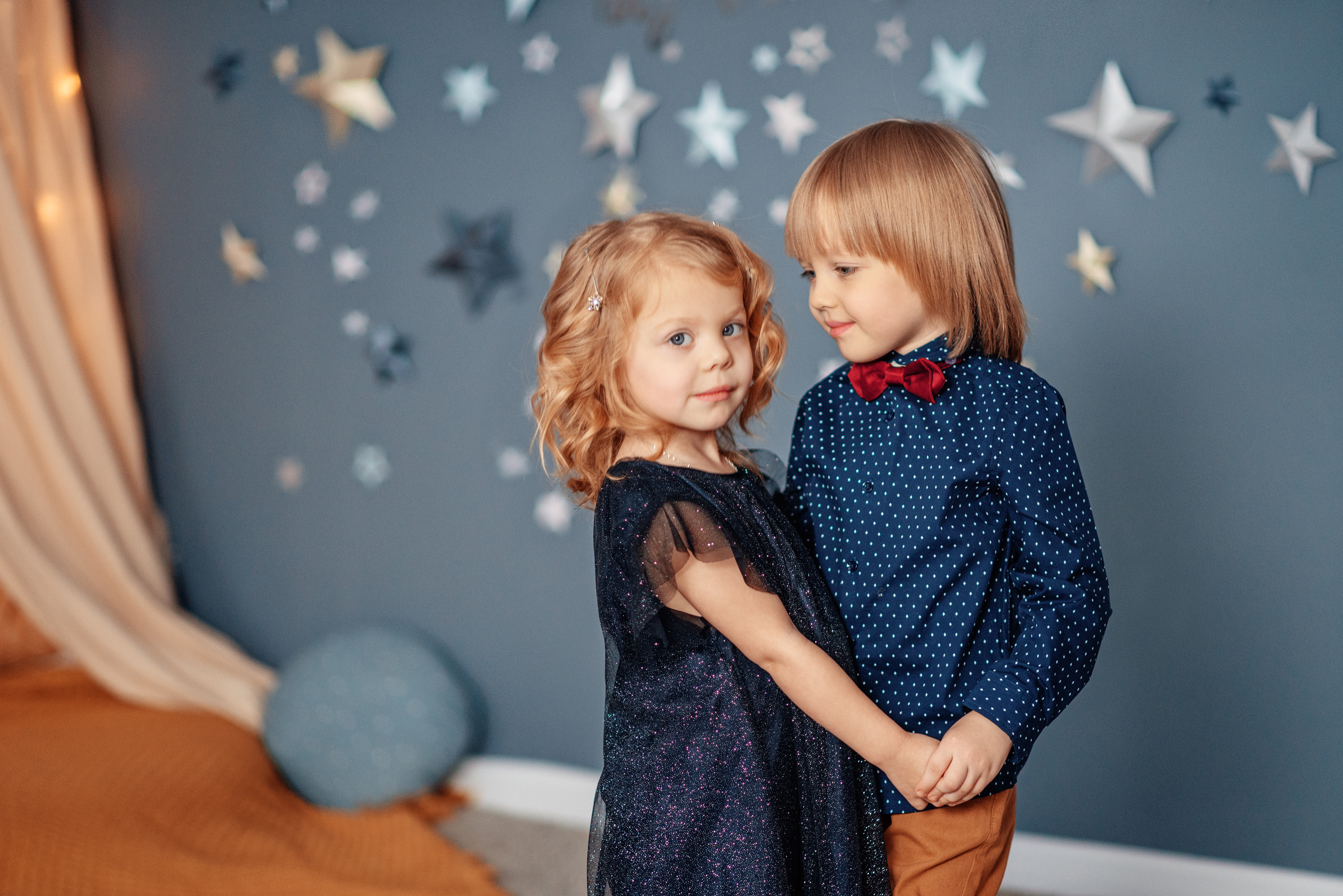 Маленькие мальчик и девочка танцуют, взявшись за руки.