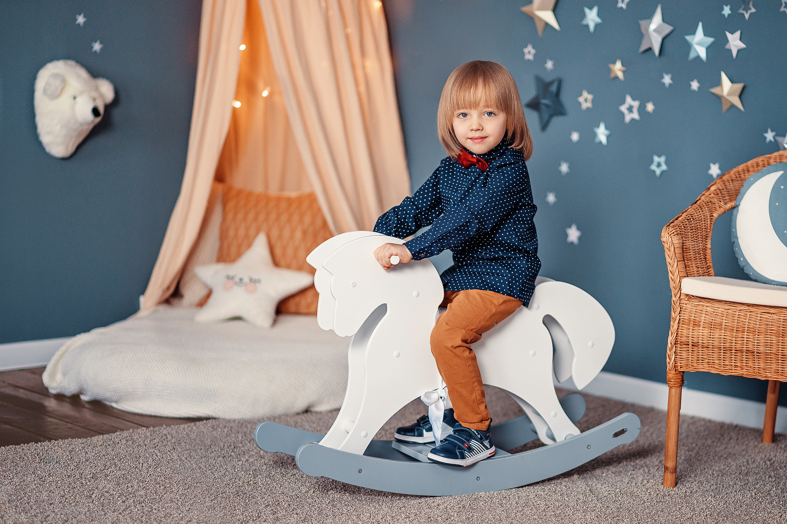 Мальчик на игрушечной лошадке в студии.