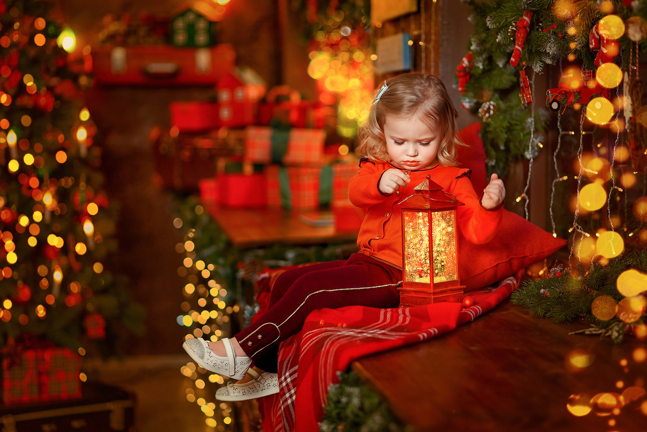 Девочка в новогодней студии рассматривает волшебный фонарь.