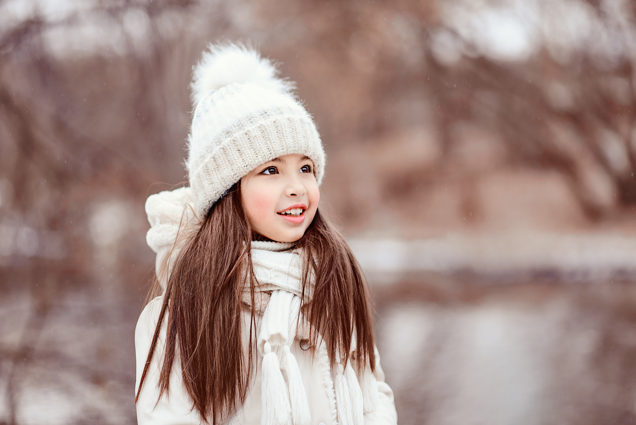 Крупный портрет красивой девочки на фоне зимнего пейзажа.