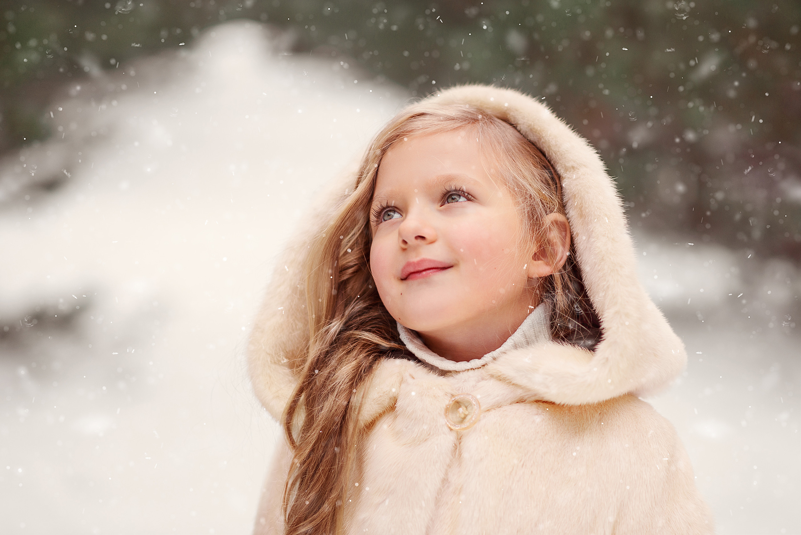 Портрет девочки в бежевой шубке на фоне зимнего пейзажа.