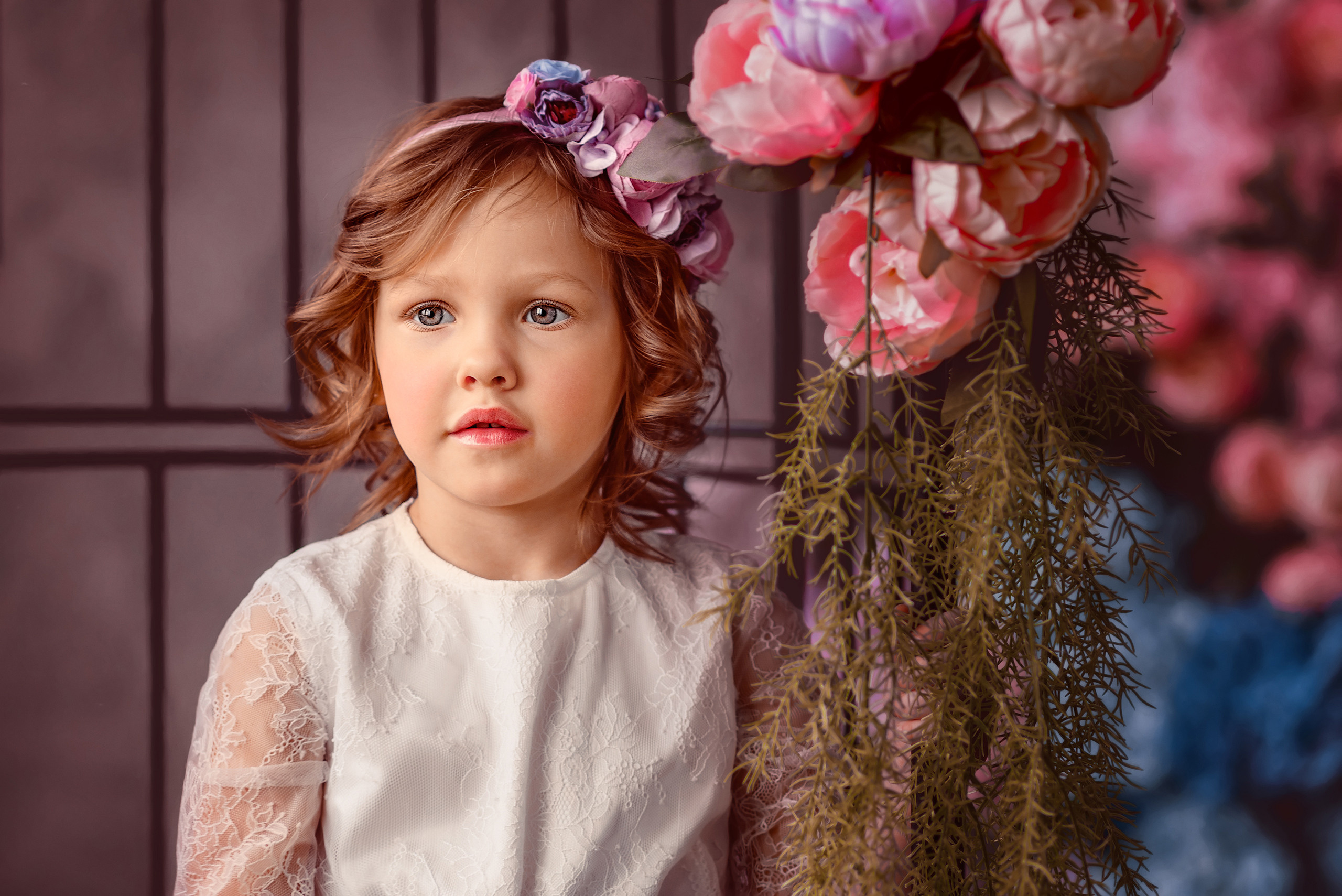 Девочка с цветочным венком на голове в весеннем студийном фотопроекте.