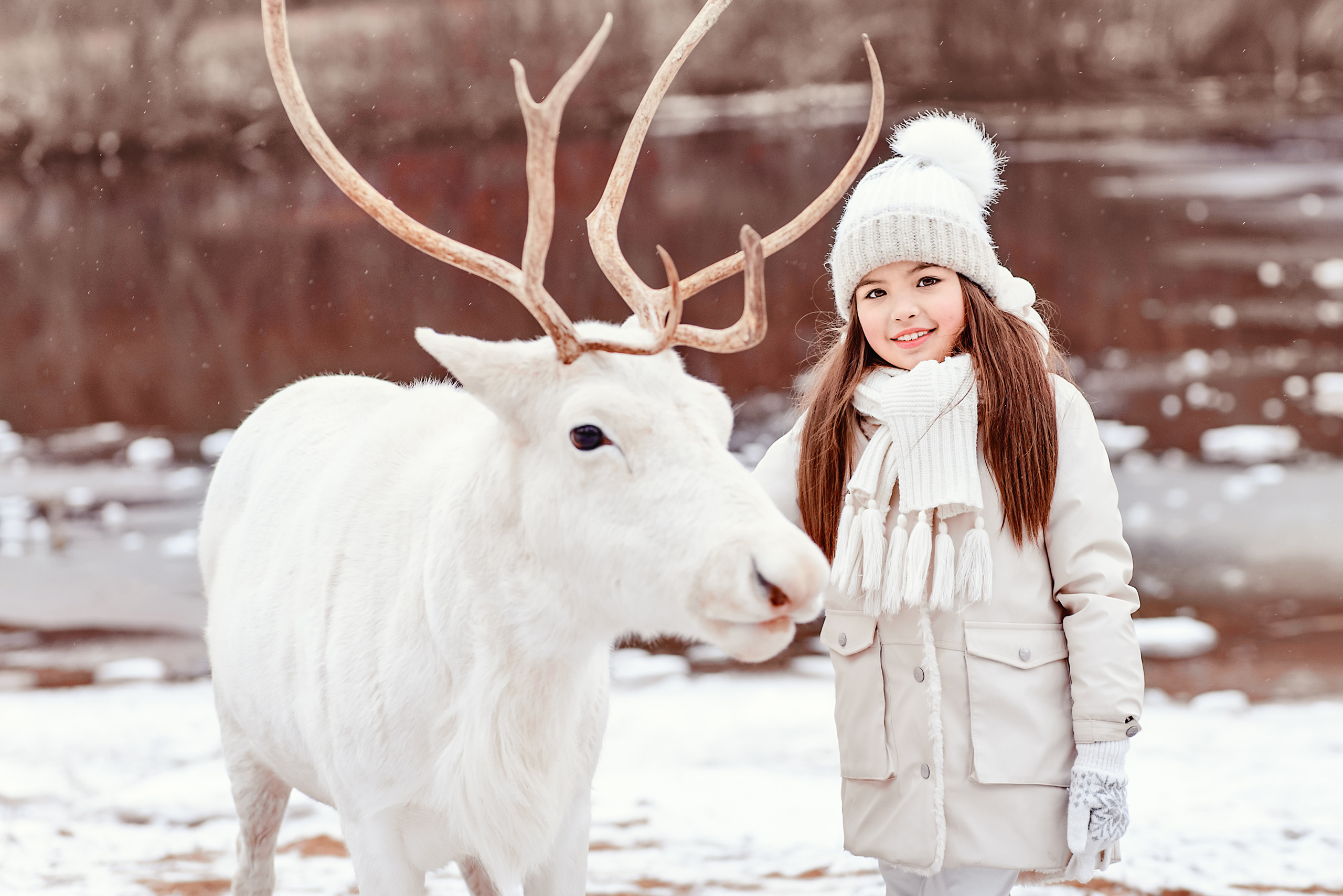 Девочка с оленем в зимнем парке.