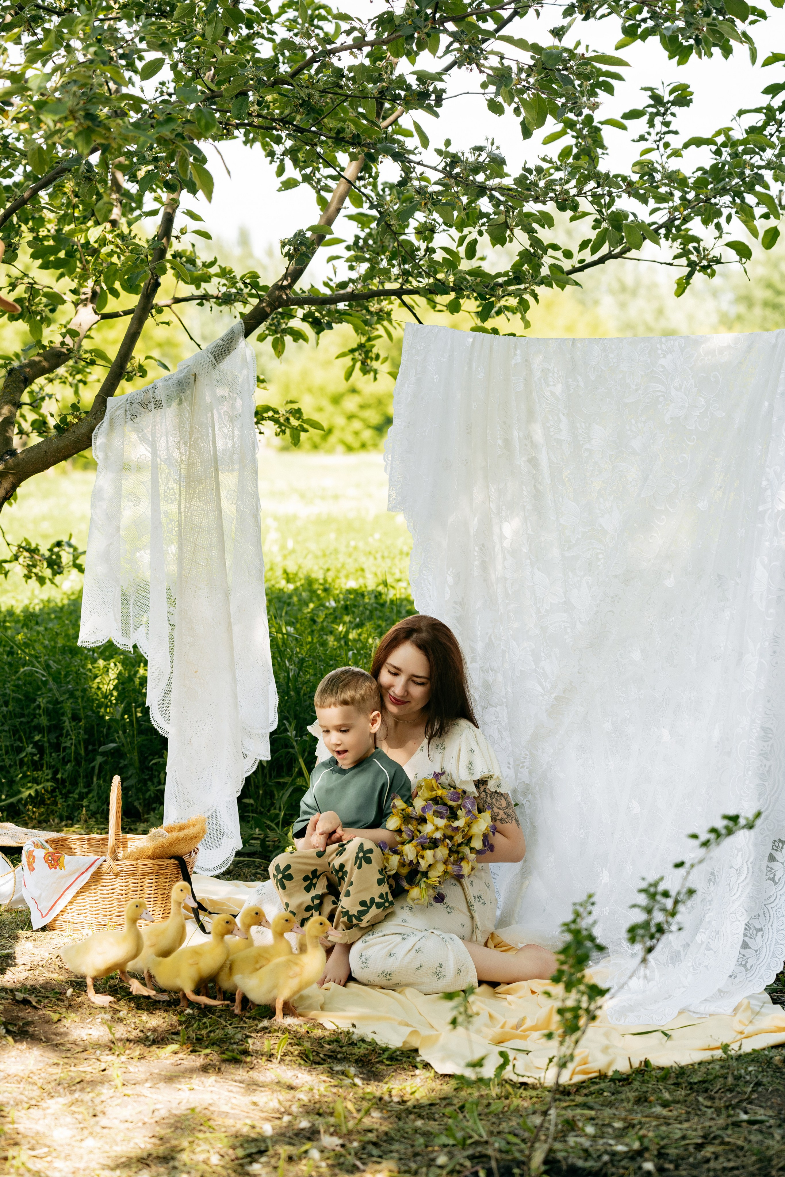Мама и сын улыбаются, наблюдая за утятами, в солнечный день, фотограф Анапа