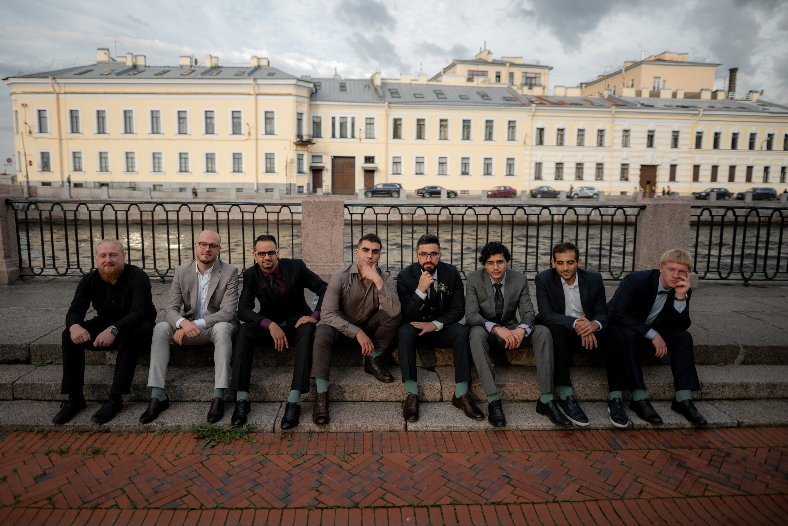 друзья жениха сидят на набережной летнего сада