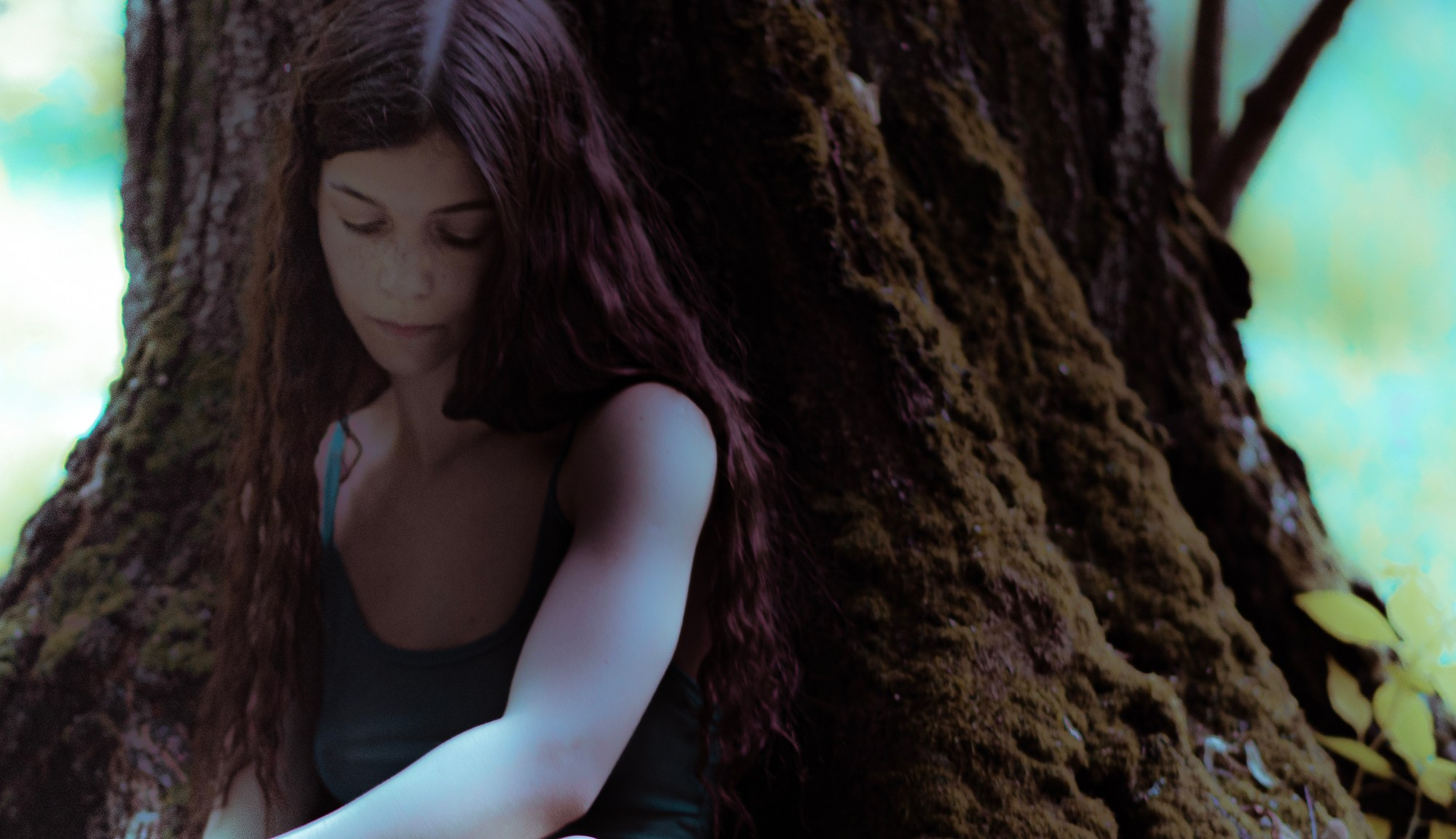 утонченная девушка фея в лесу у массивного дерева