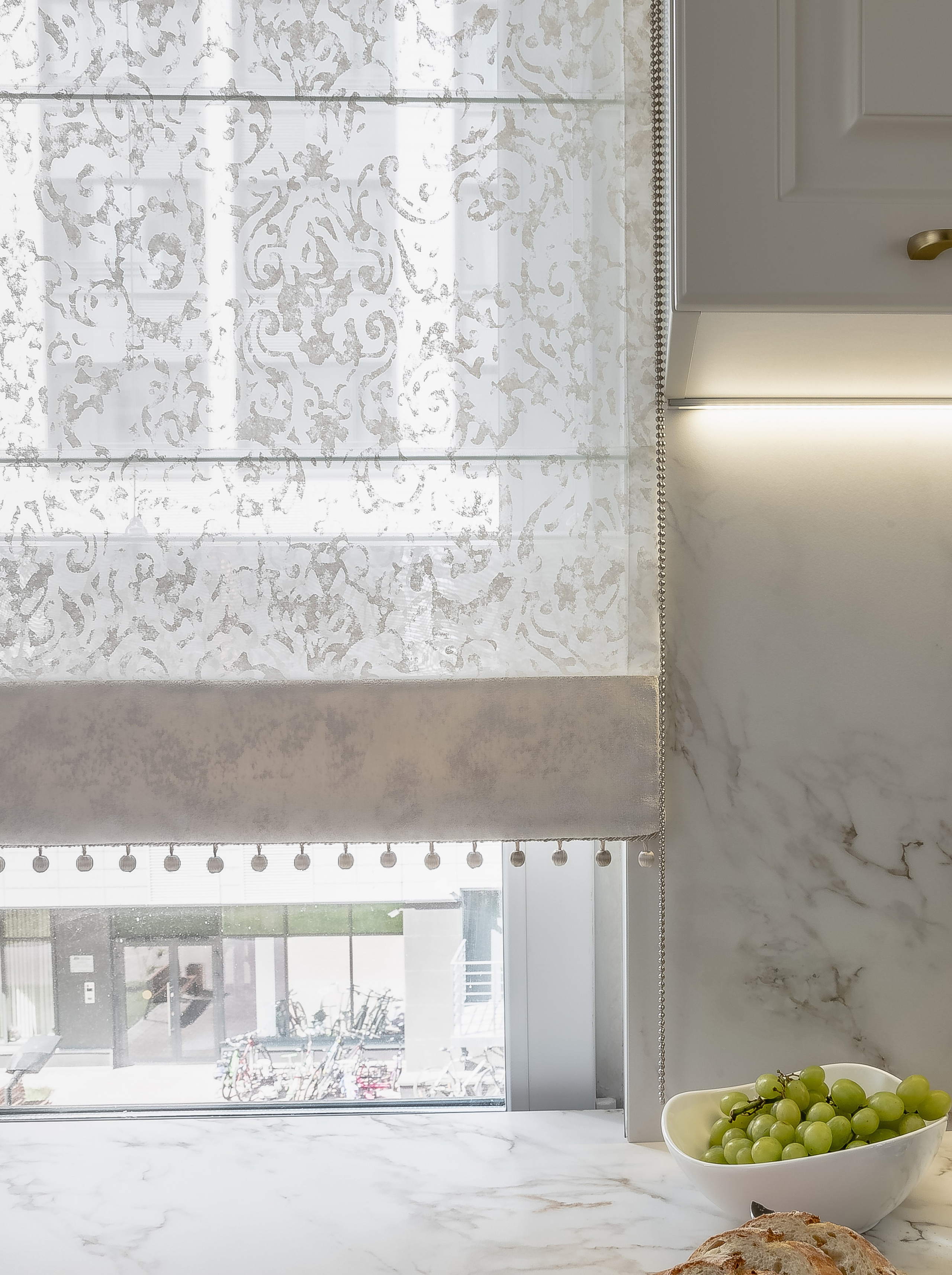 Тюлевая римская штора с кантом по низу на окне в кухне