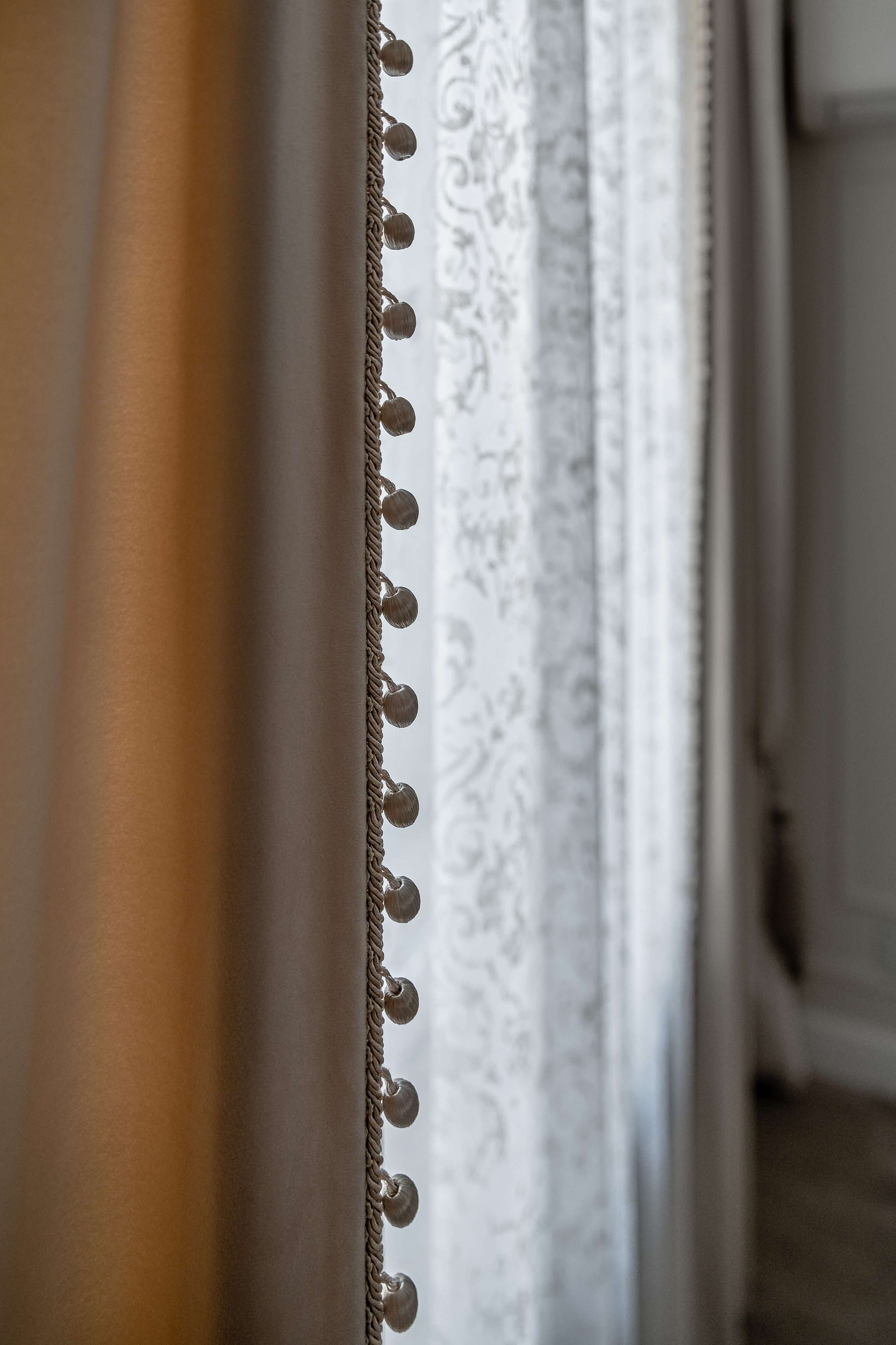 Бархатная штора с бахромой-шариками крупный план