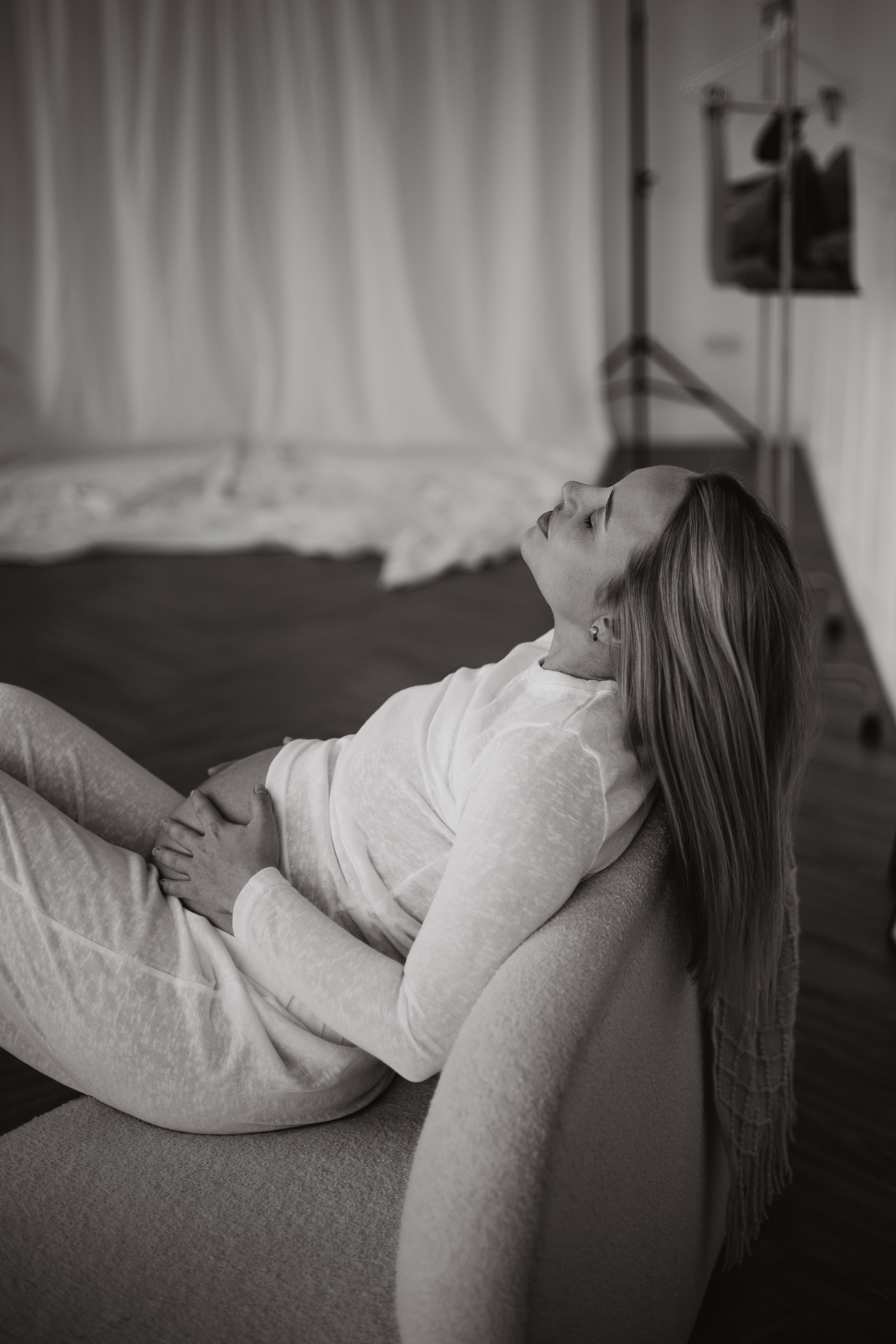 Светлая съемка для беременных: мягкий студийный свет окутывает фигуру будущей мамы, подчеркивая нежность кожи и живота.