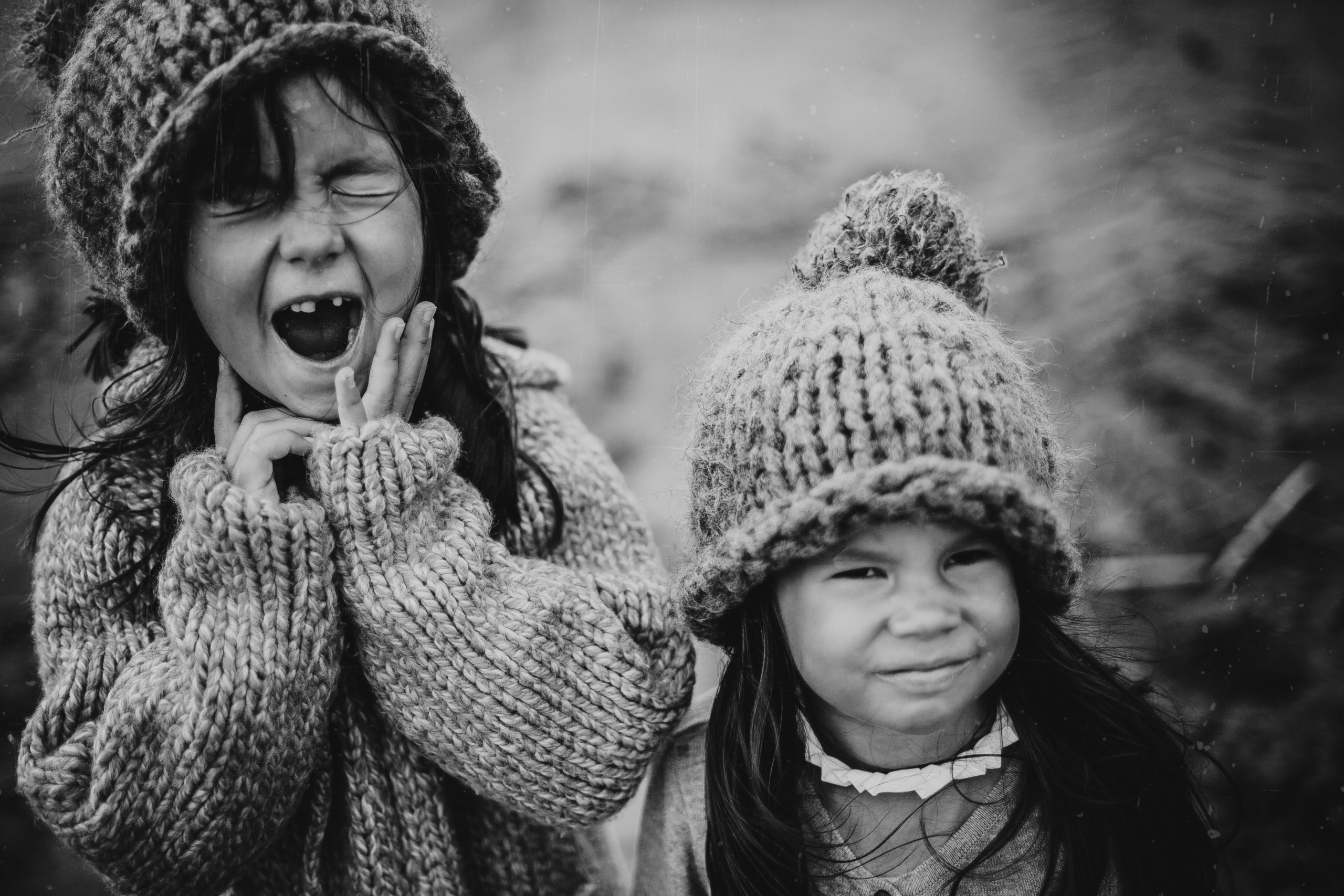 портрет двух маленьких сестер в вязаных шапках