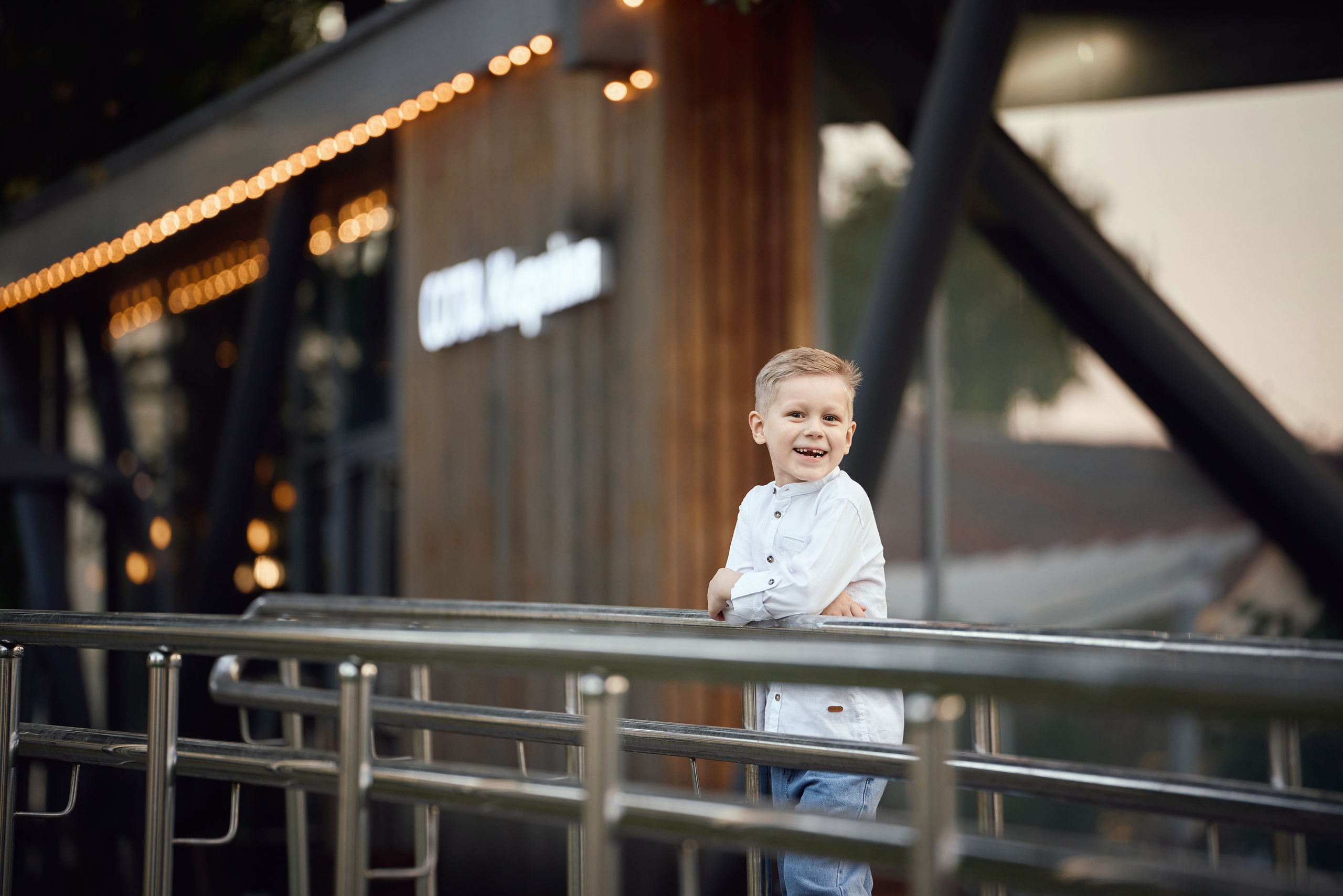 мальчик стоит на лестнице у большого стеклянного окна ресторана на территории ВДНХ