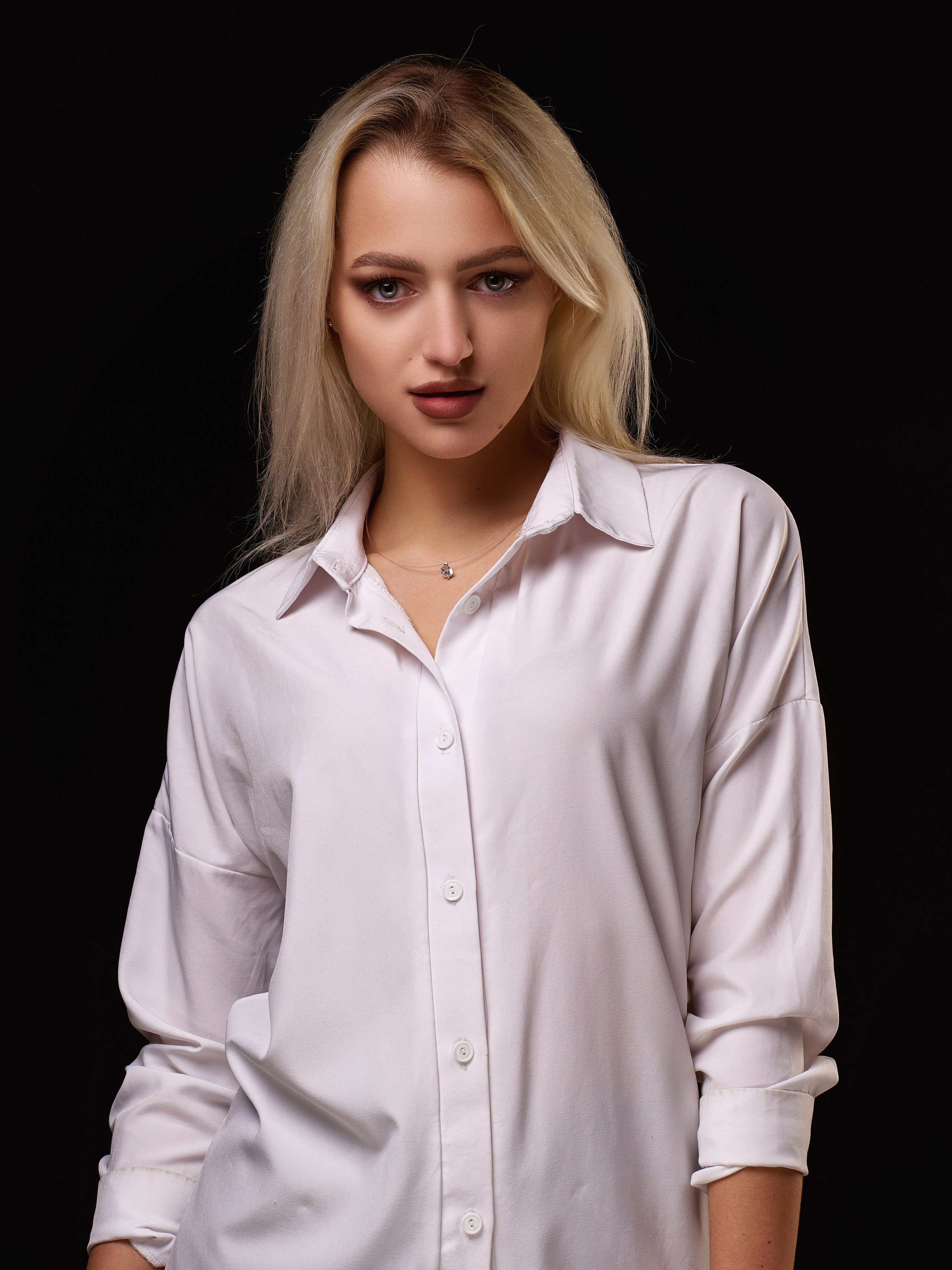 поясной портрет девушки блондинки на чёрном фоне