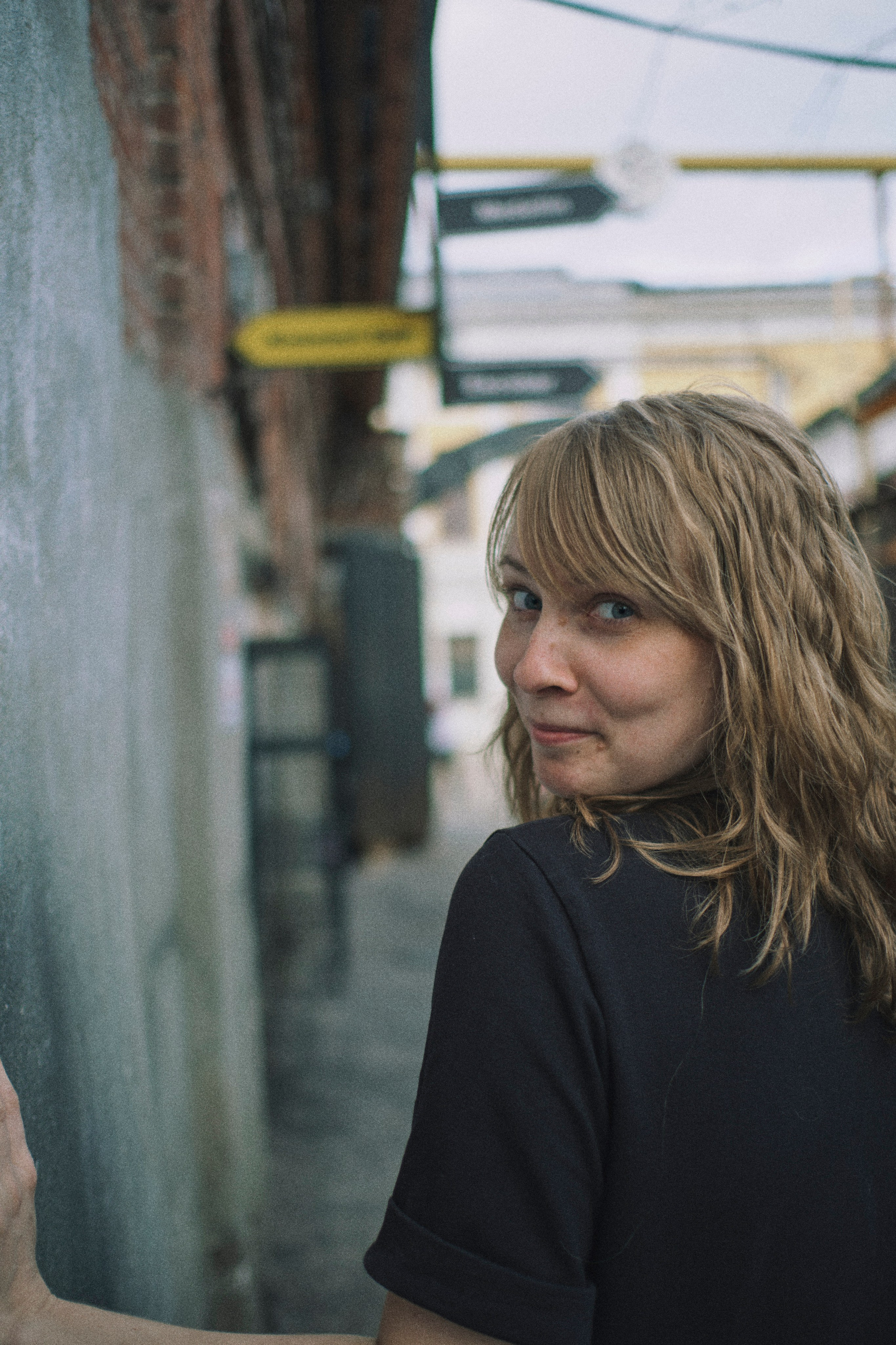 Девушка идет по проулку, оборачиваясь