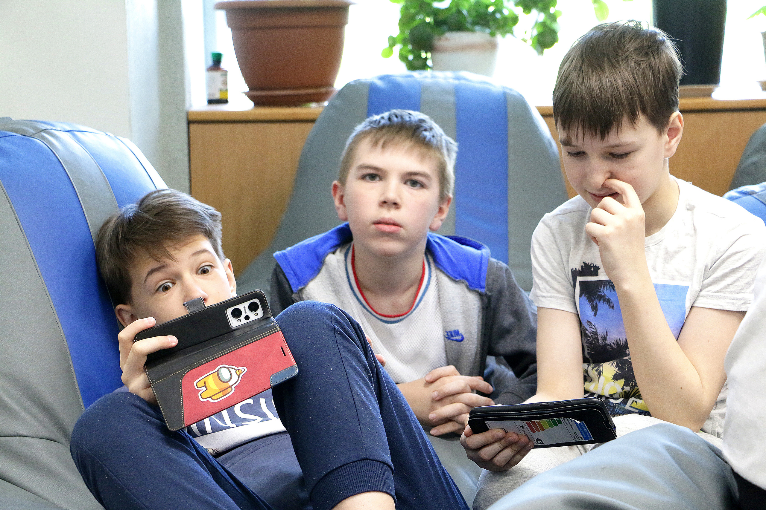 Мобильный телефон всегда в руках. Мальчишки играют на телефоне