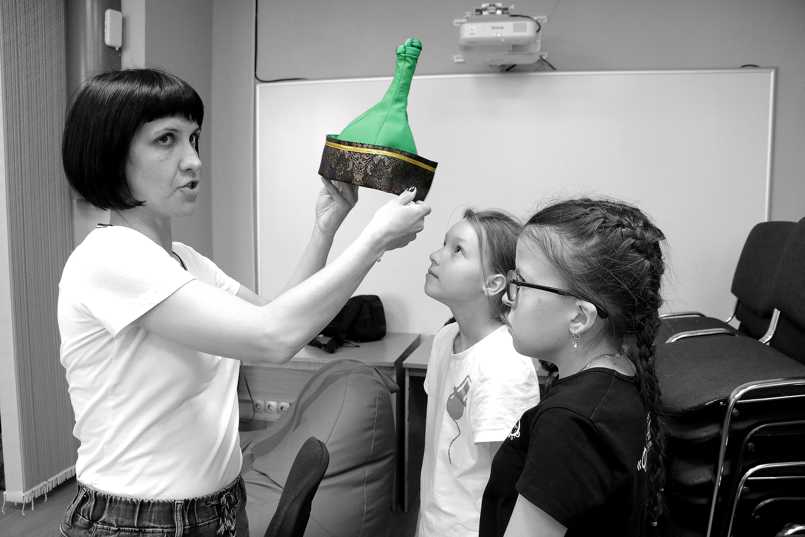 Юные актрисы девочки готовятся к спектаклю. Женщина костюмер подготовила костюмы для девочек